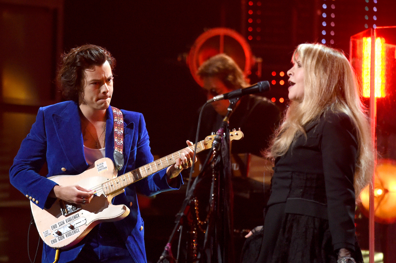 Harry Styles wearing blue while performing with Stevie Nicks in black during Nicks' induction into the Rock & Roll Hall of Fame in 2019.
