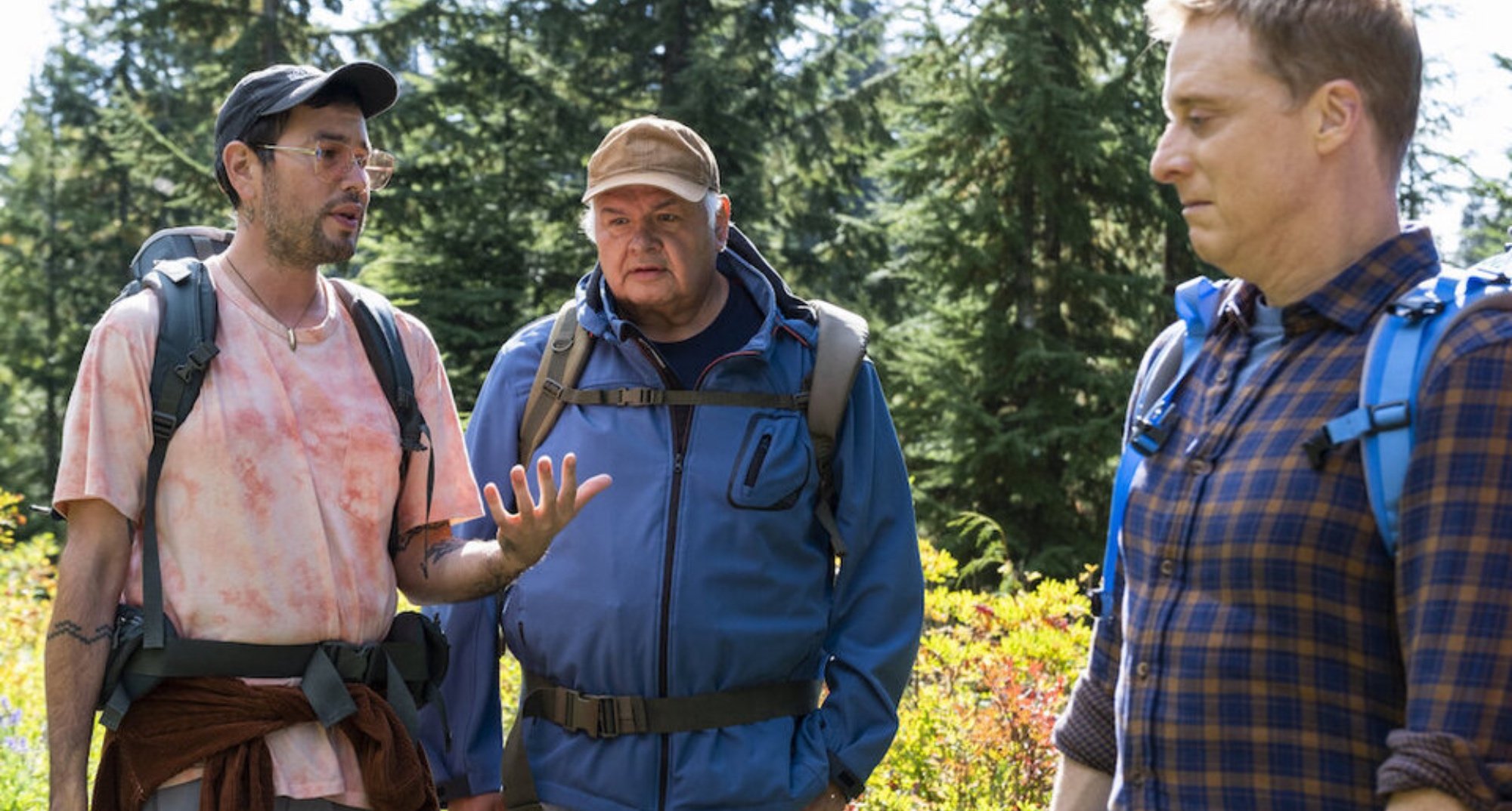 Harry and supporting characters in 'Resident Alien' Season 2 Episode 4 wearing hiking gear in woods.