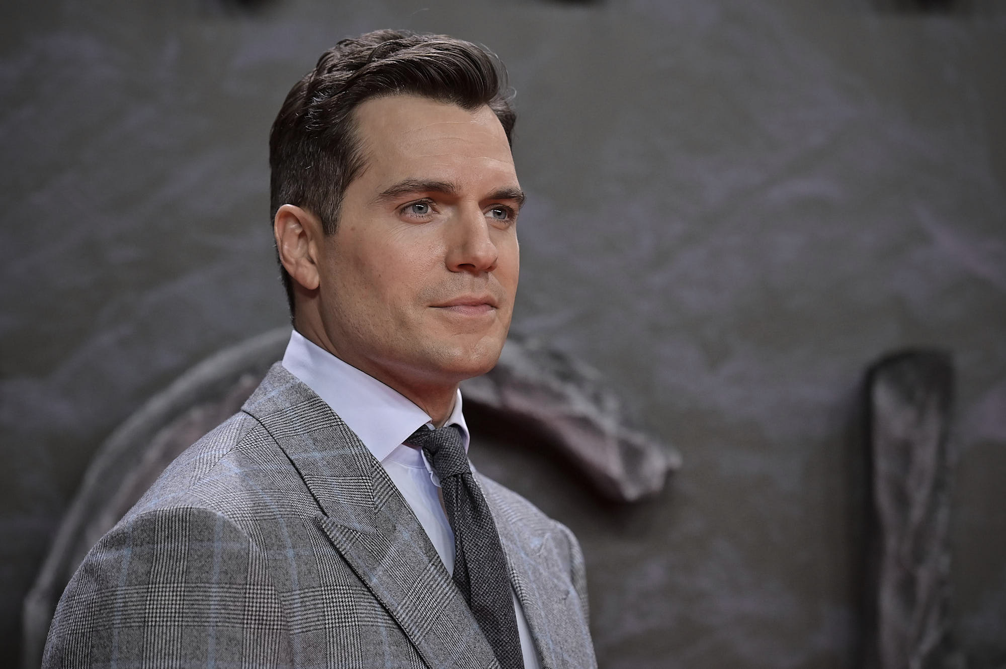 'The Witcher' and Superman star Henry Cavill. He's wearing a grey suit and his hair is slicked back.