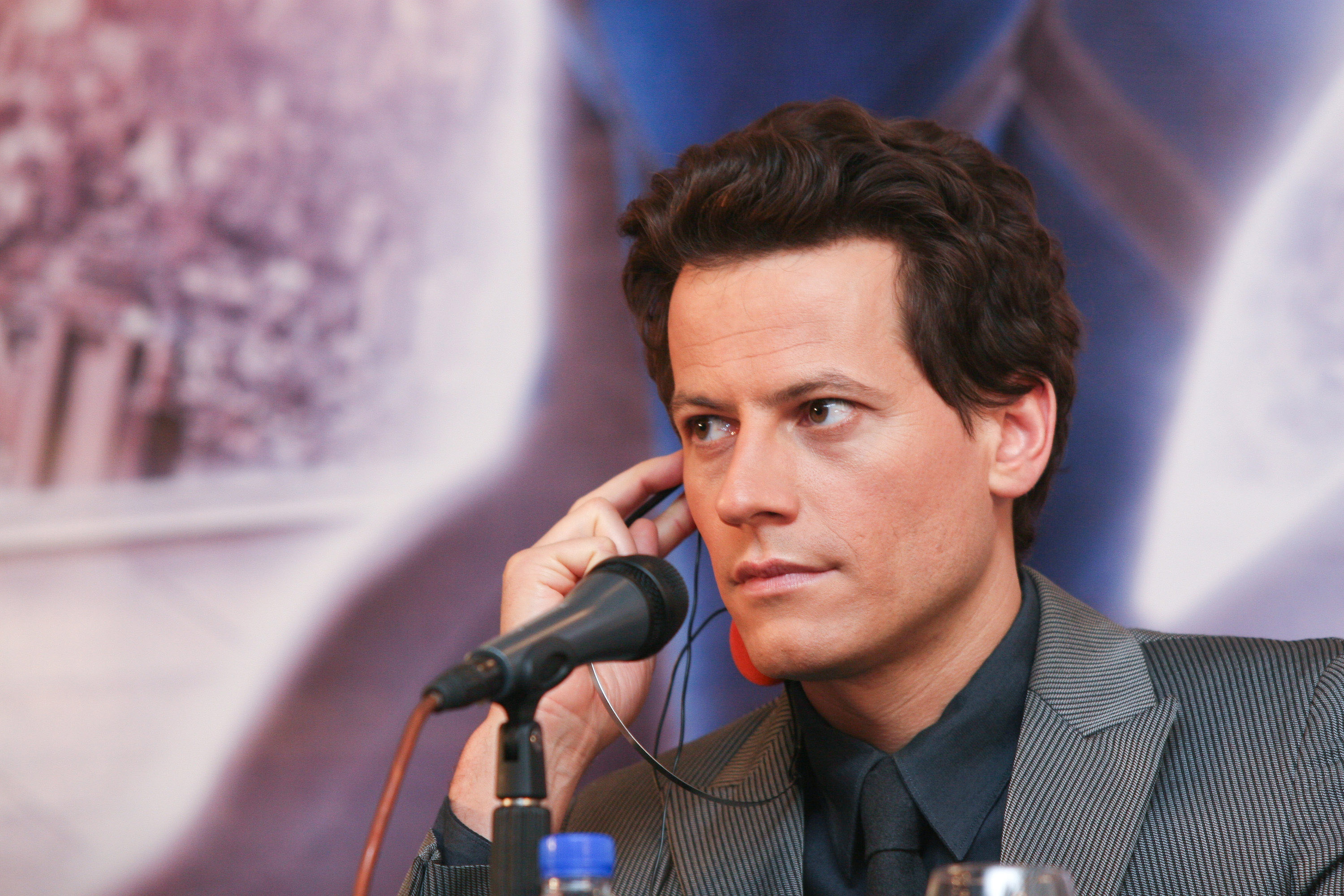 Ioan Gruffudd, who played Reed Richards in 'Fantastic Four,' the character who may be in 'Doctor Strange in the Multiverse of Madness,' wears a gray striped suit over a dark blue button-up shirt and tie.