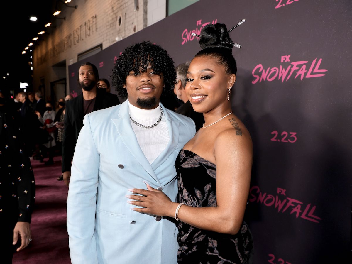 Isaiah John and Gail Bean pose together for a photo at an event for 'Snowfall' as DeRay Davis stands off to the side