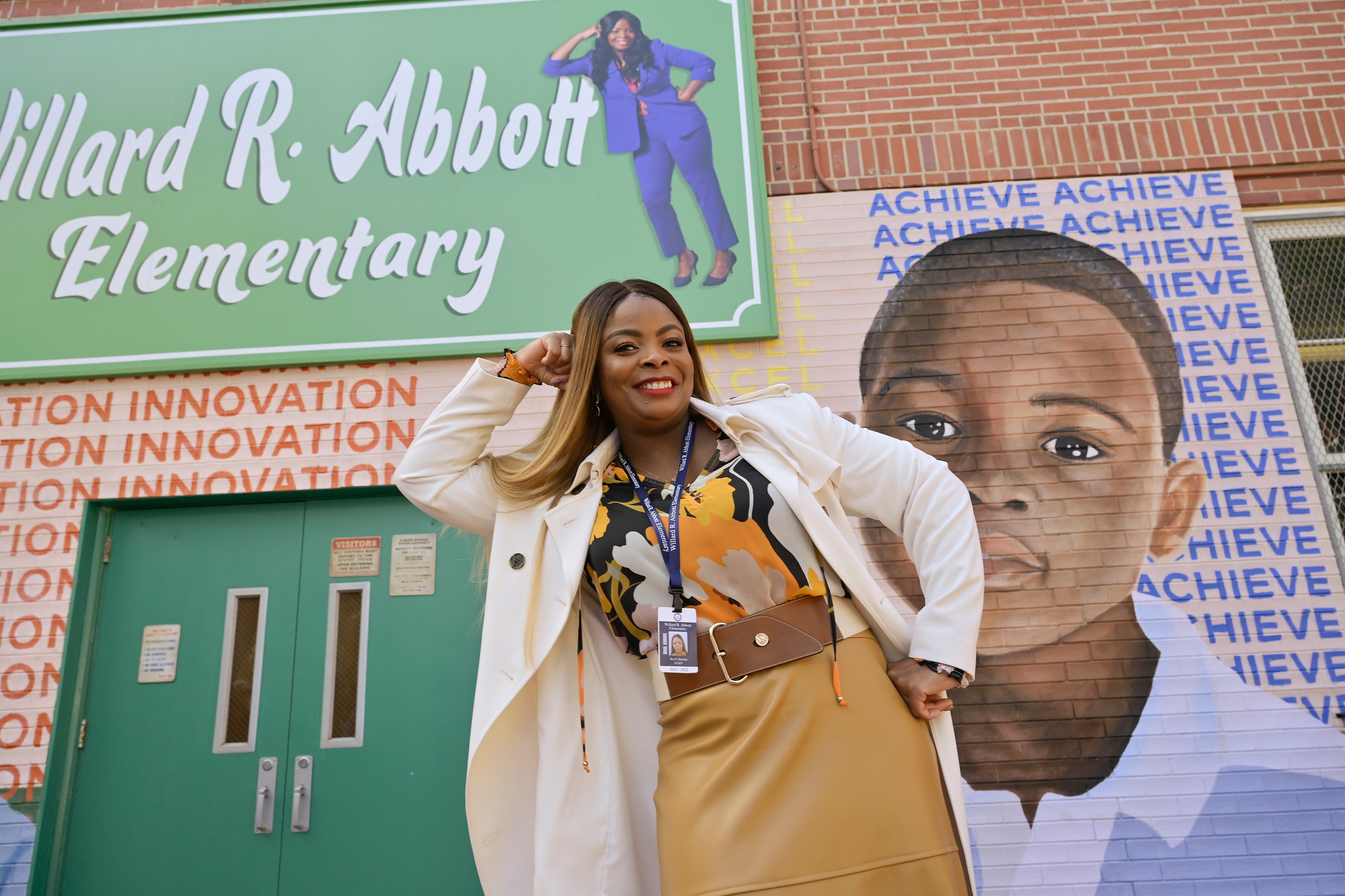 'Abbott Elementary' star Janelle James as Ava Coleman wearing a white jacket and posing outside of where 'Abbott Elementary' filmed.