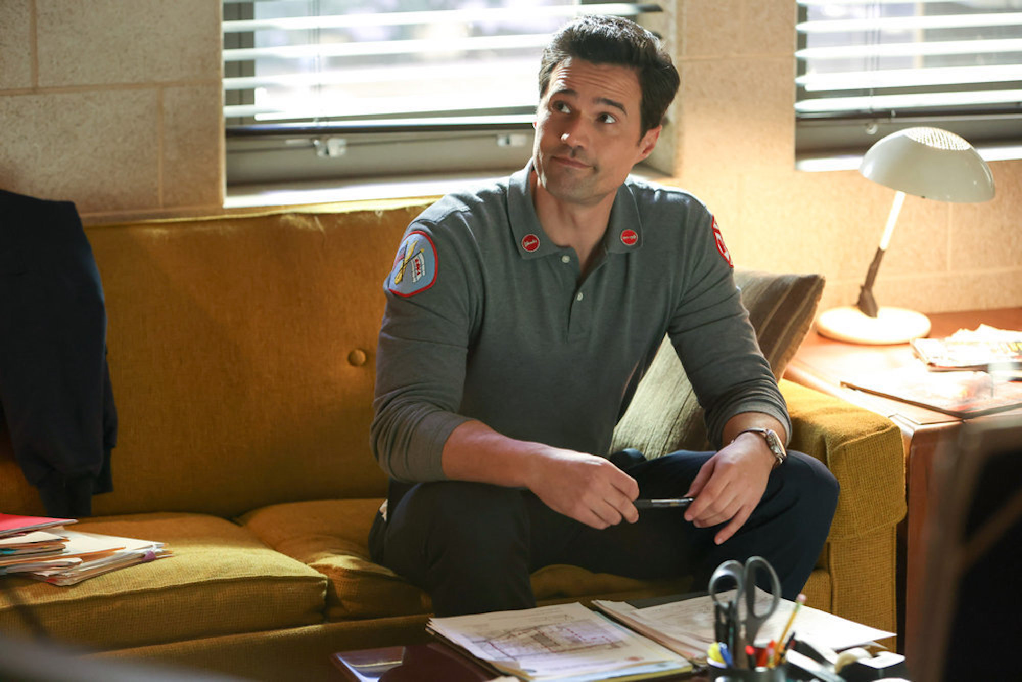 Brett Dalton as Jason Pelham sitting on a couch in 'Chicago Fire' Season 10 Episode 13