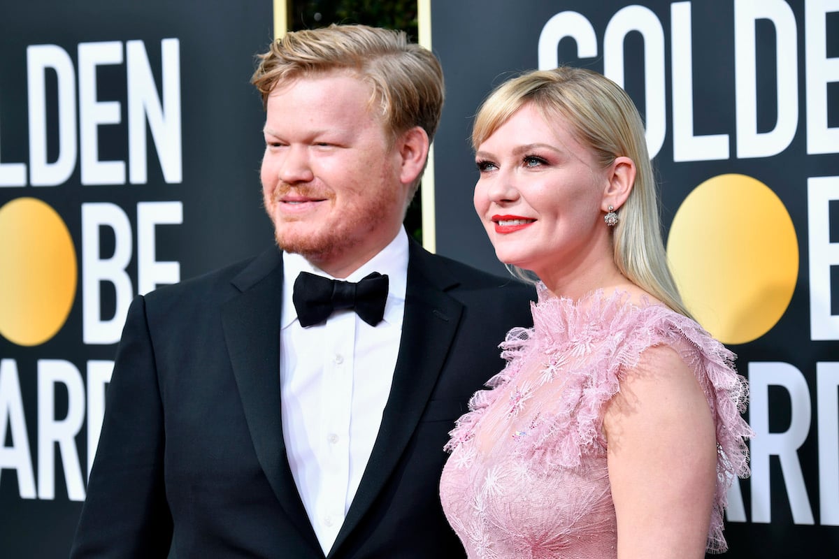 Jesse Plemons wears a suit and Kirsten Dunst wears a pink dress on the red carpet