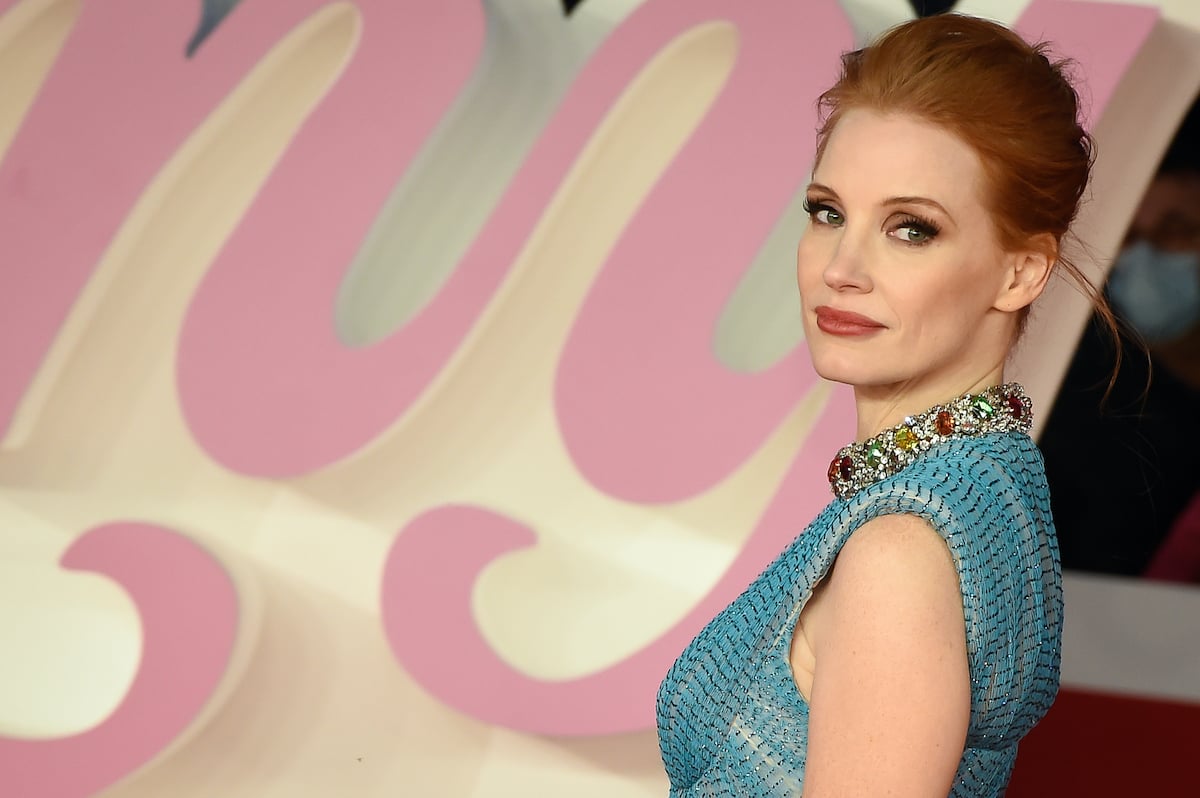 Jessica Chastain wears a blue dress while smiling on the red carpet