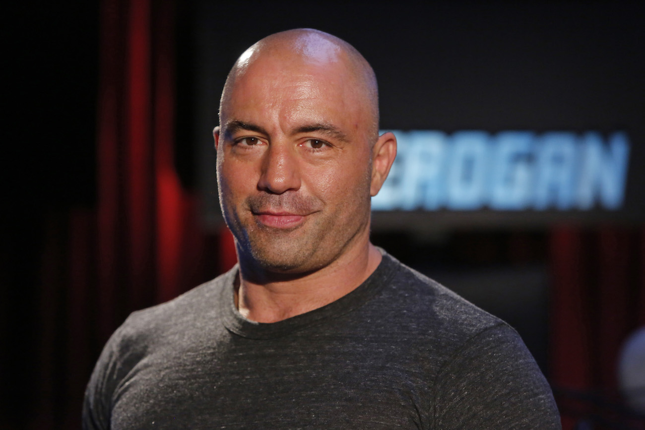 Joe Rogan wearing a gray shirt, looking into the camera