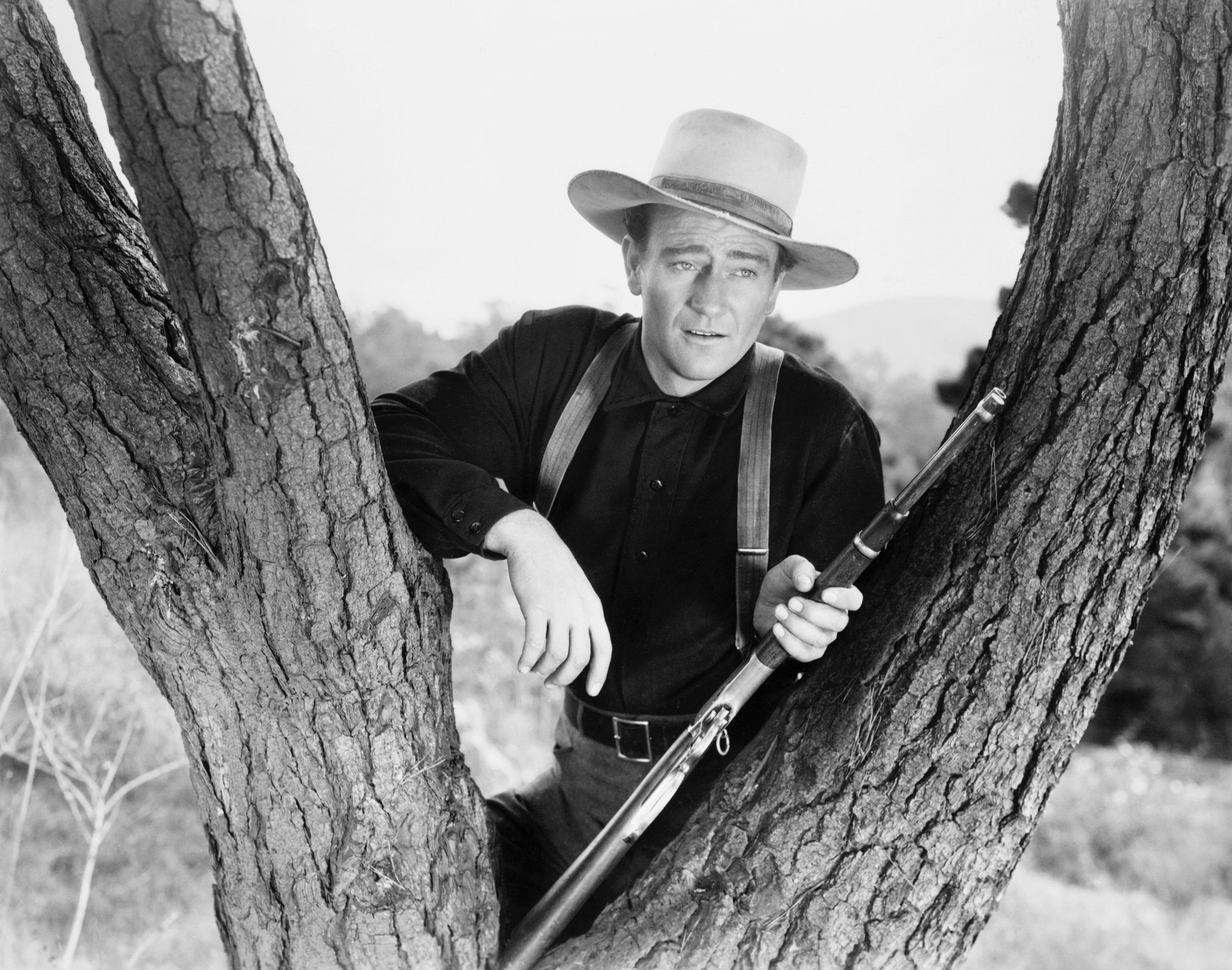 John Wayne in article about turning down Steven Spielberg role leaning on a tree with a gun