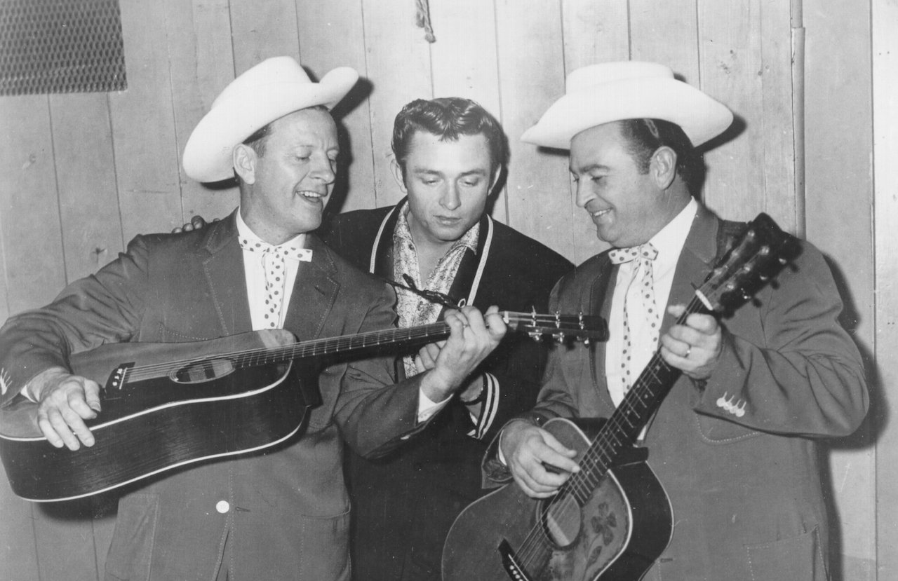 Johnnie Wright and Jack Anglin flank country singer/songwriter Johnny Cash as they pose for a portrait in circa 1957. 