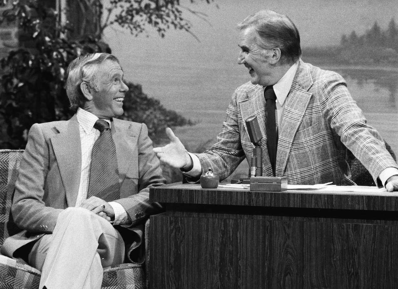 Johnny Carson and Ed McMahon laugh as they trade places at 'The Tonight Show' desk c. 1976