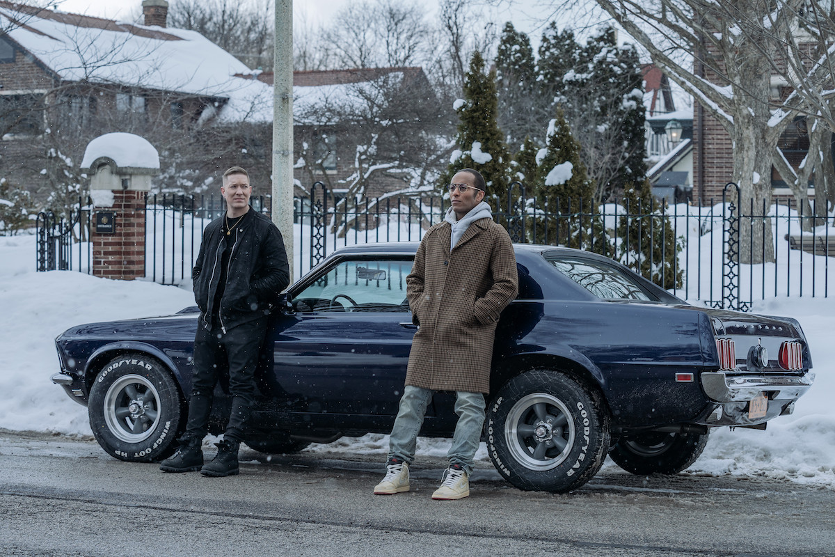 Joseph Sikora as Tommy Egan and Anthony Fleming as JP Gibbs leaning against a mustang in the snow in 'Power Book IV: Force