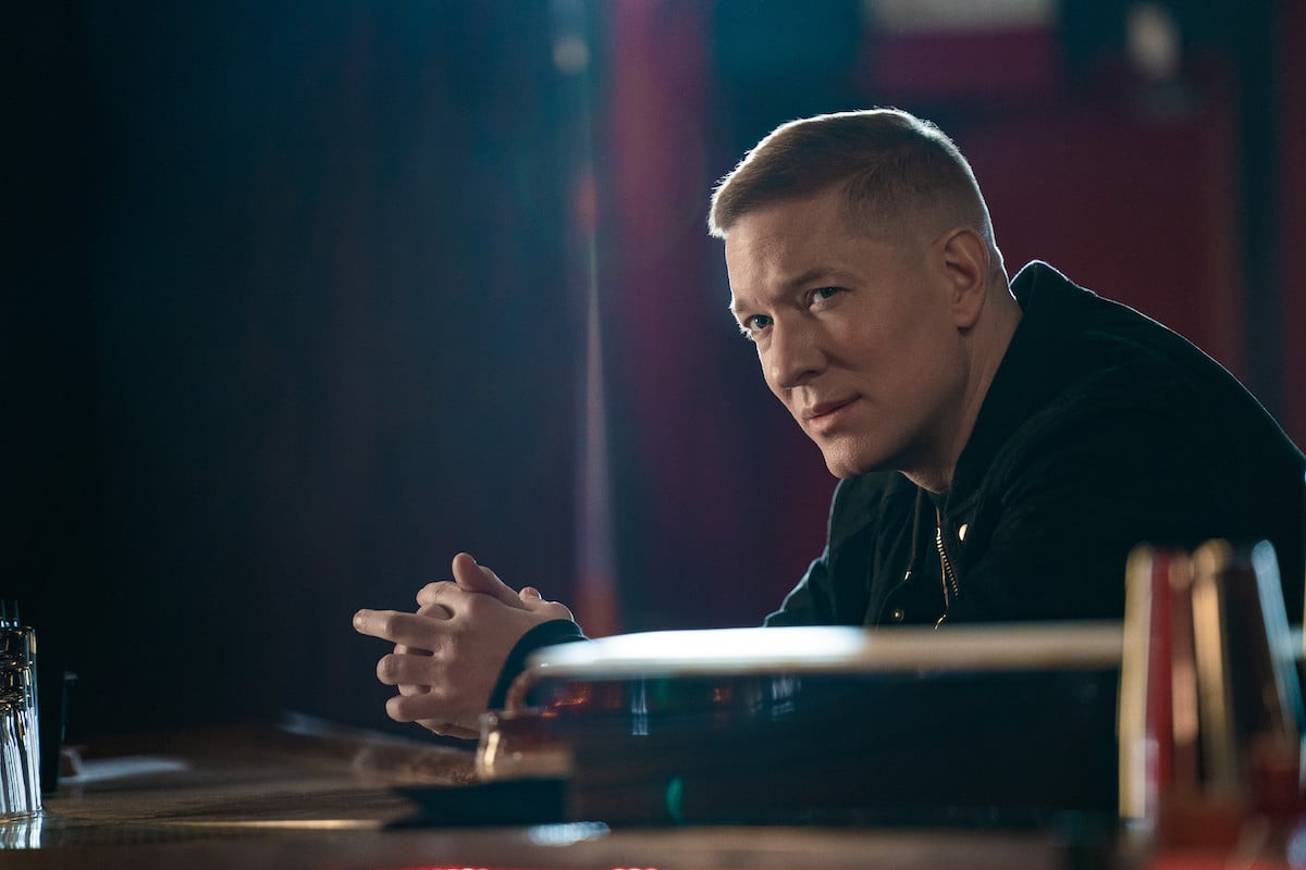Joseph Sikora sits at a bar wearing all black as Tommy Egan in 'Power Book IV: Force'