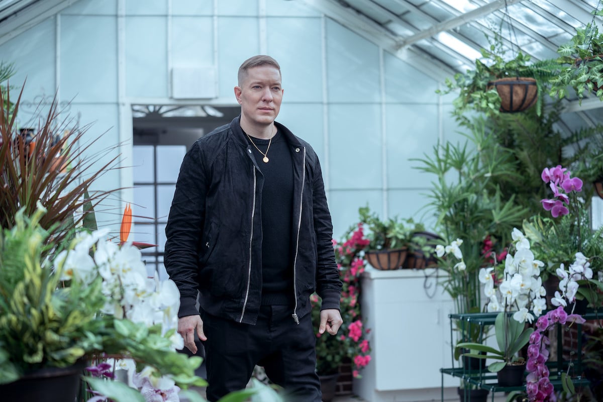 Joseph Sikora as Tommy Egan wearing all black and standing in a garden in 'Power Book IV: Force'