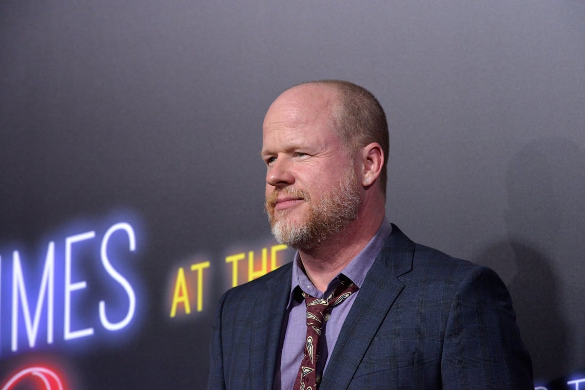 Joss Whedon posing while wearing a suit.