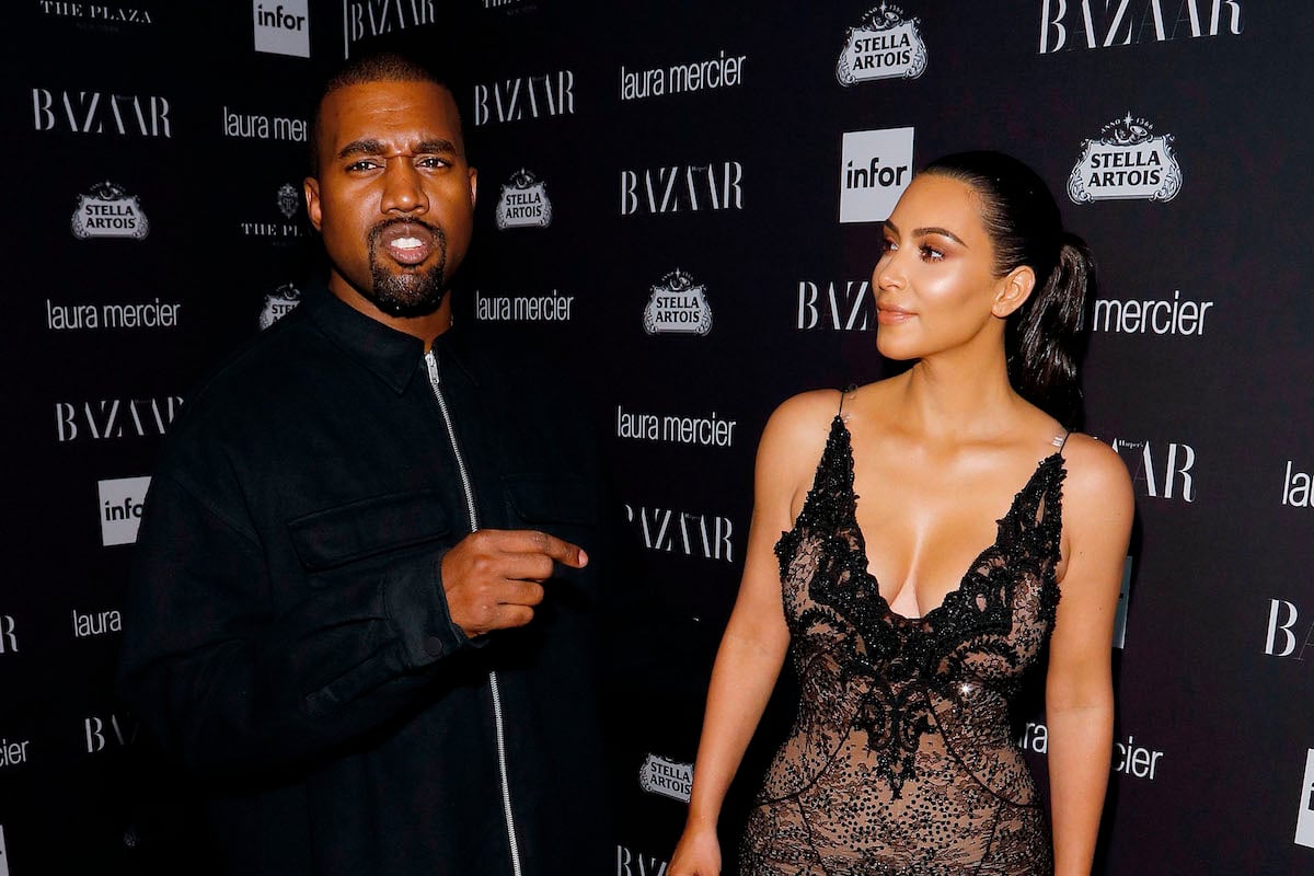 Kanye West points at Kim Kardashian West at an event.