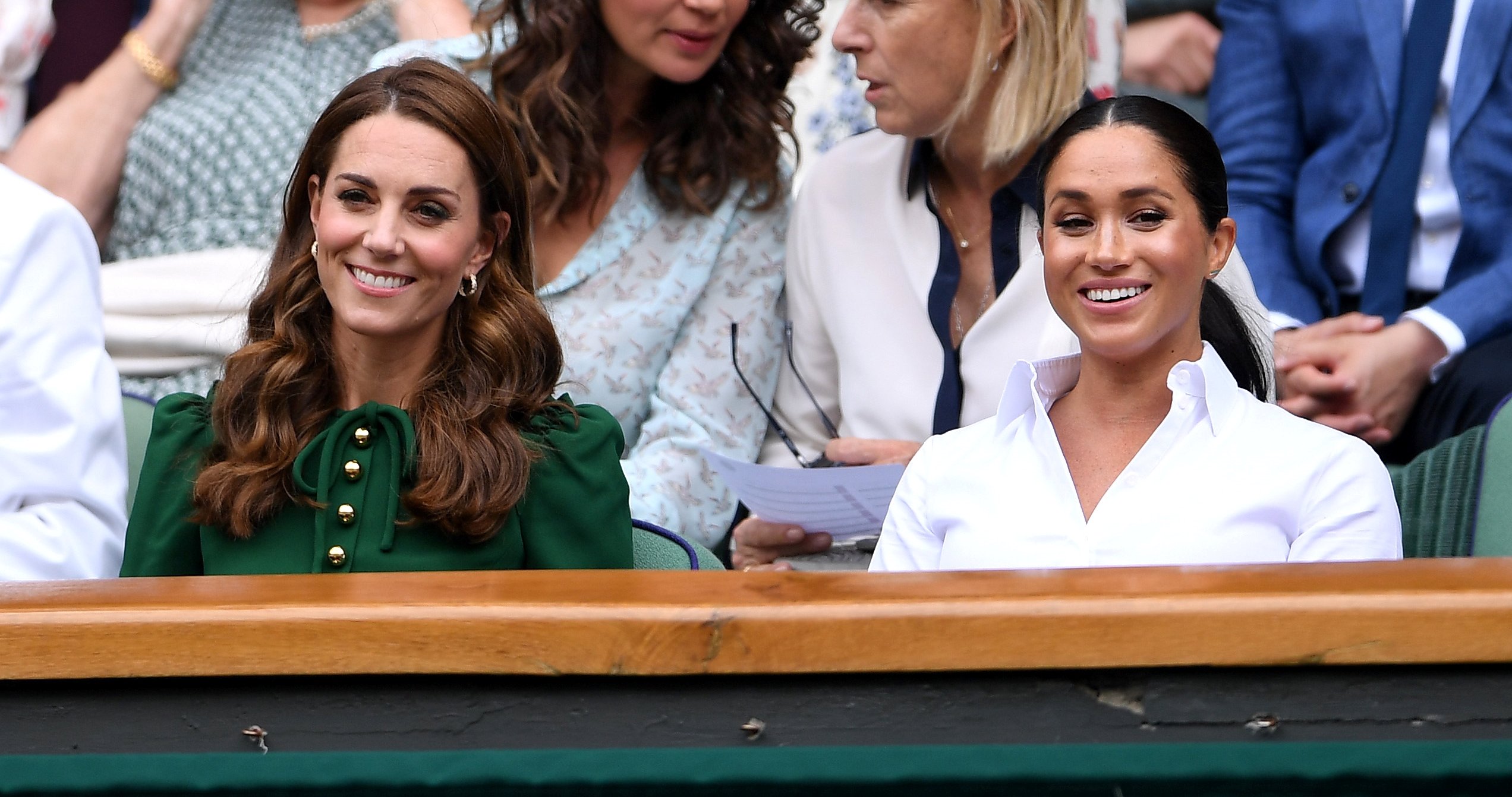Kate Middleton and Meghan Markle smiling during the Wimbledon Championships in 2019