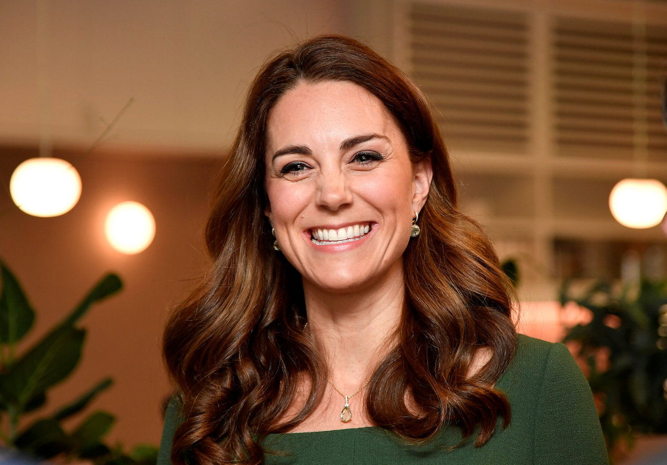 Kate Middleton smiling in a green outfit