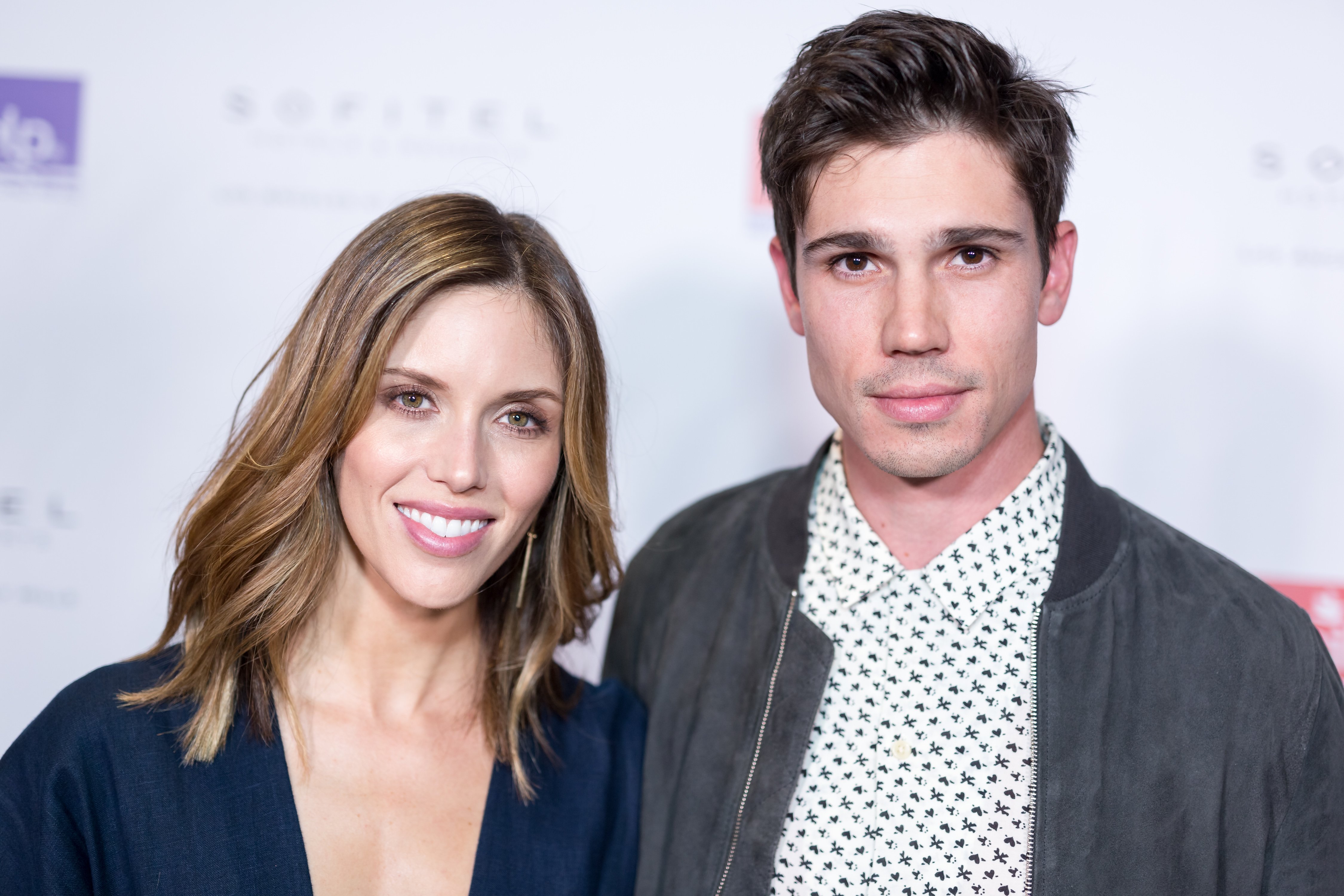 'The Bold and the Beautiful' actor Kayla Ewell in a blue dress, and Tanner Novlan in a black jacket and white shirt.