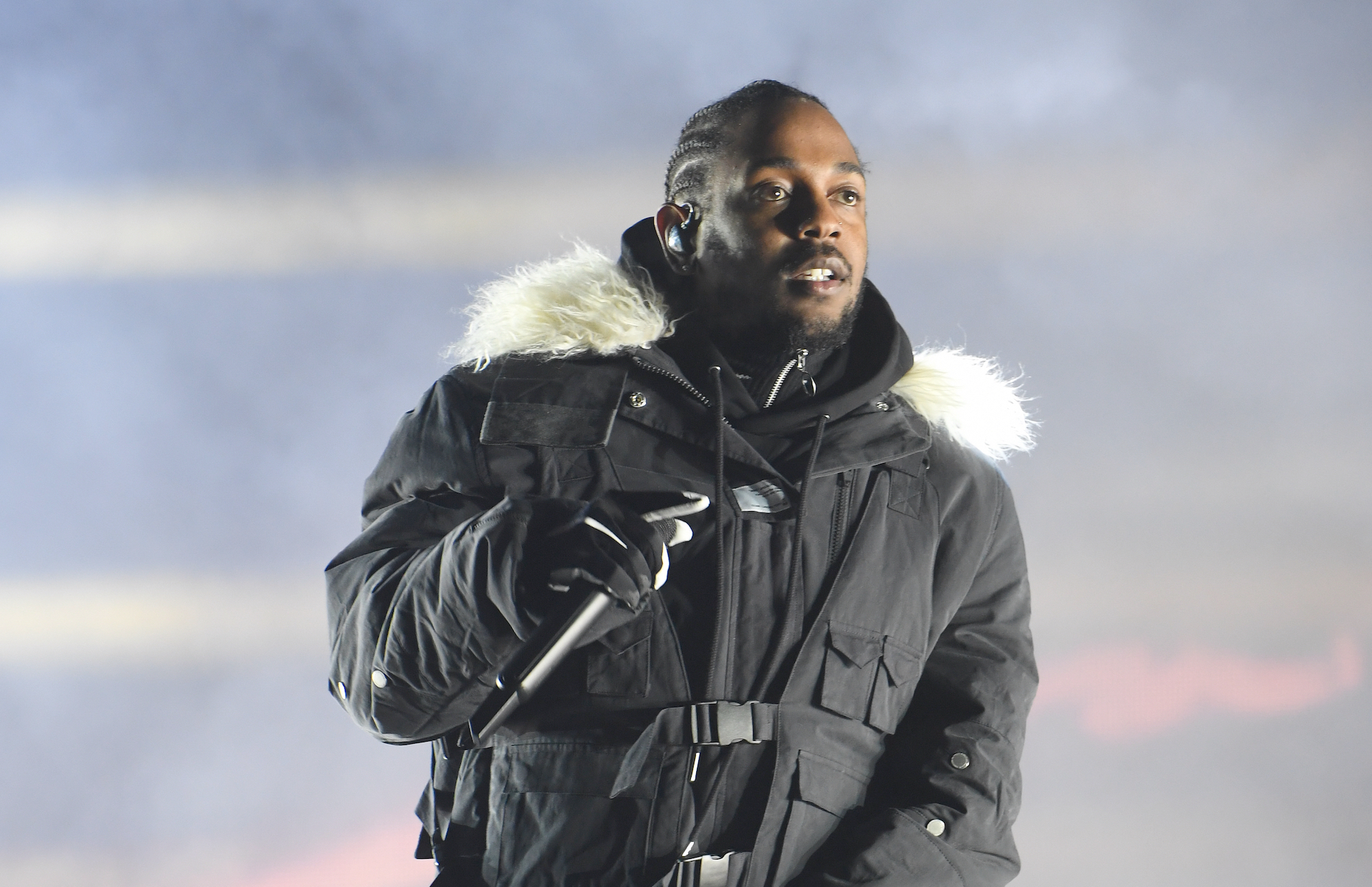 Kendrick Lamar wearing a jacket on stage
