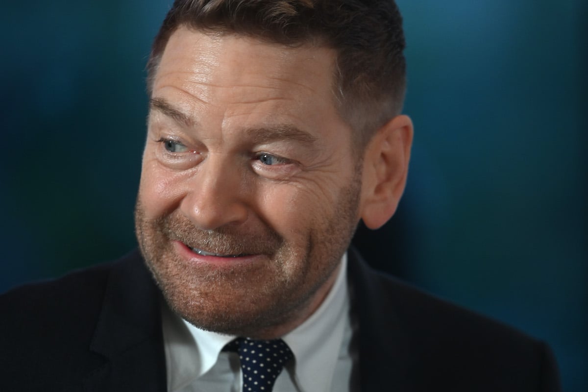 Kenneth Branagh wears a suit and smiles