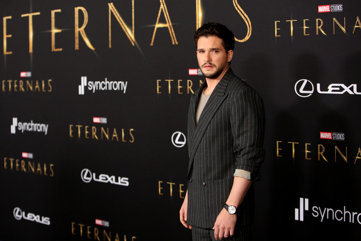 Kit Harington in a pinstripe jacket and t-shirt arrives at the Premiere of Marvel Studios' Eternals on October 18, 2021 in Hollywood, California