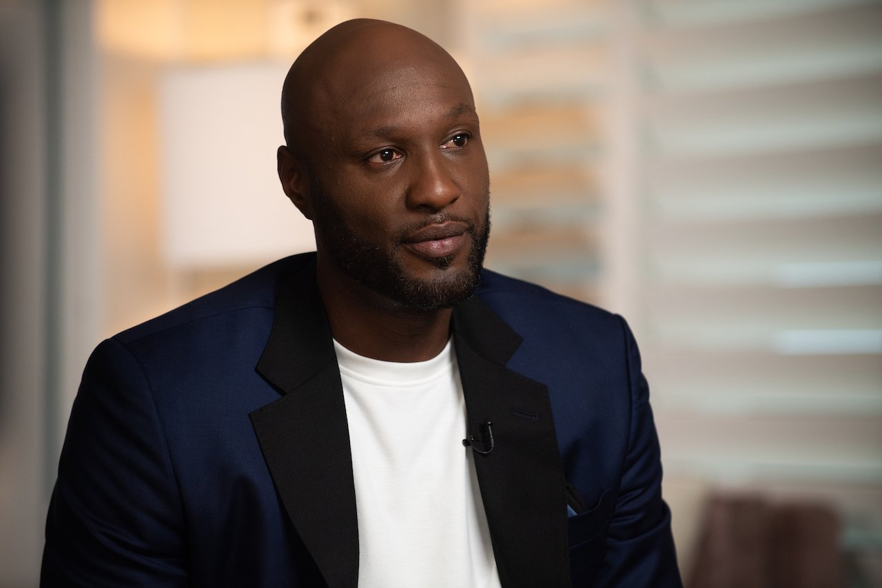 Lamar Odom sits on the set of "Good Morning America" in a white shirt and blue jacket.
