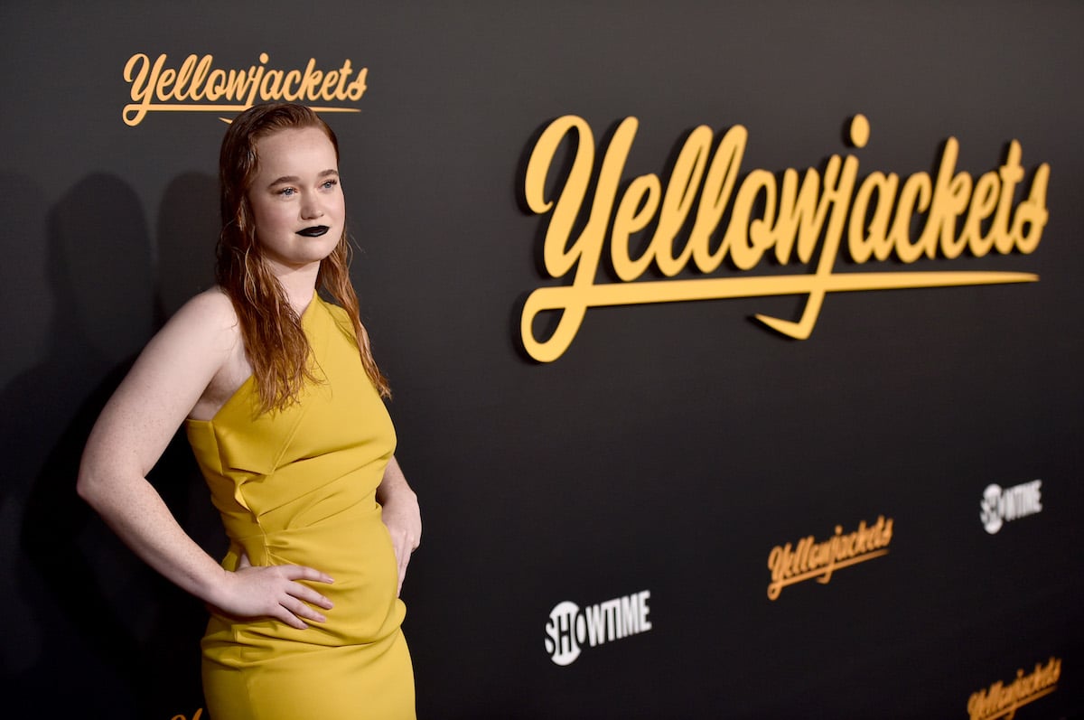 Liv Hewson poses in a yellow dress with their hands on their hips at the Premiere Of Showtime's 'Yellowjackets'.