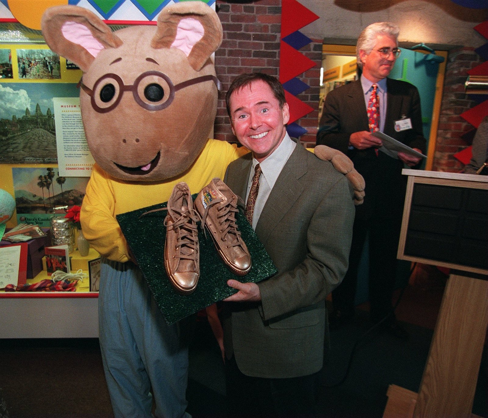 Arthur creator Marc Brown shows off a pair of sneakers that he was presented at the Boston Children's Museum