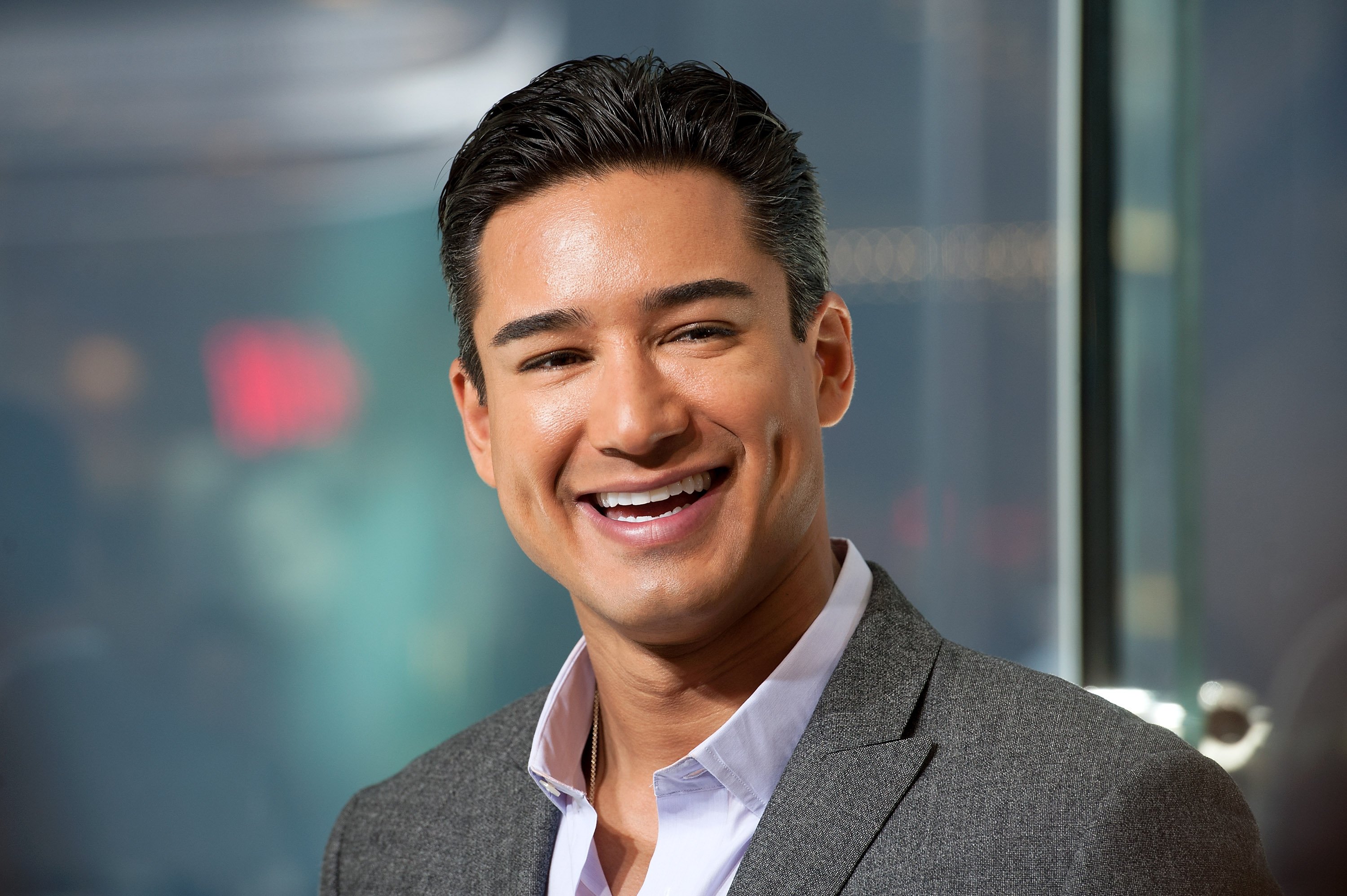 Mario Lopez smiles during an appearance hosting 'Extra.' 