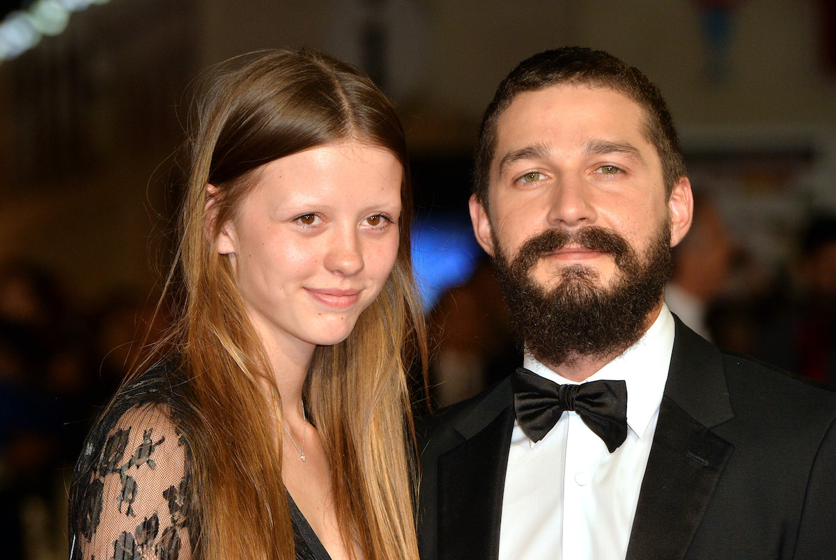 Mia Goth and Shia LaBeouf pose together at an event.