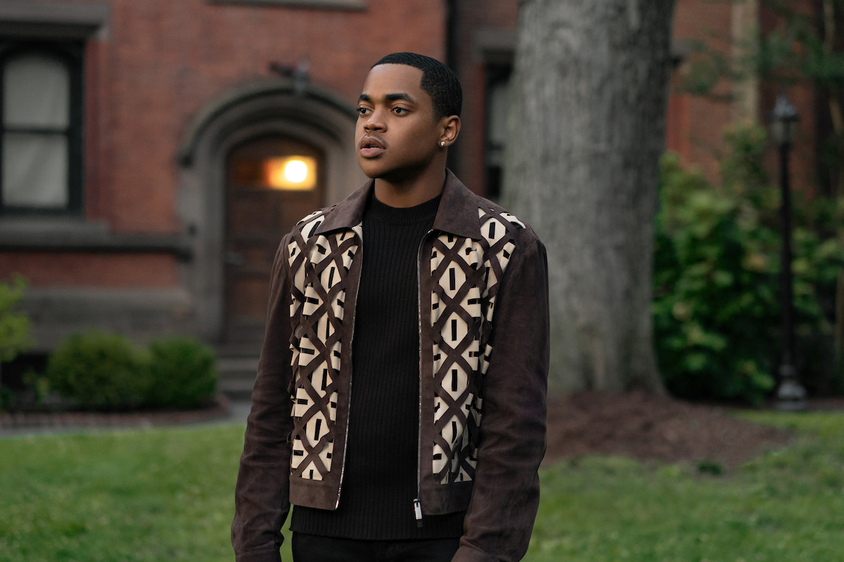 Michael Rainey Jr. as Tariq St. Patrick wearing a brown jacket and standing on campus in 'Power Book II: Ghost'