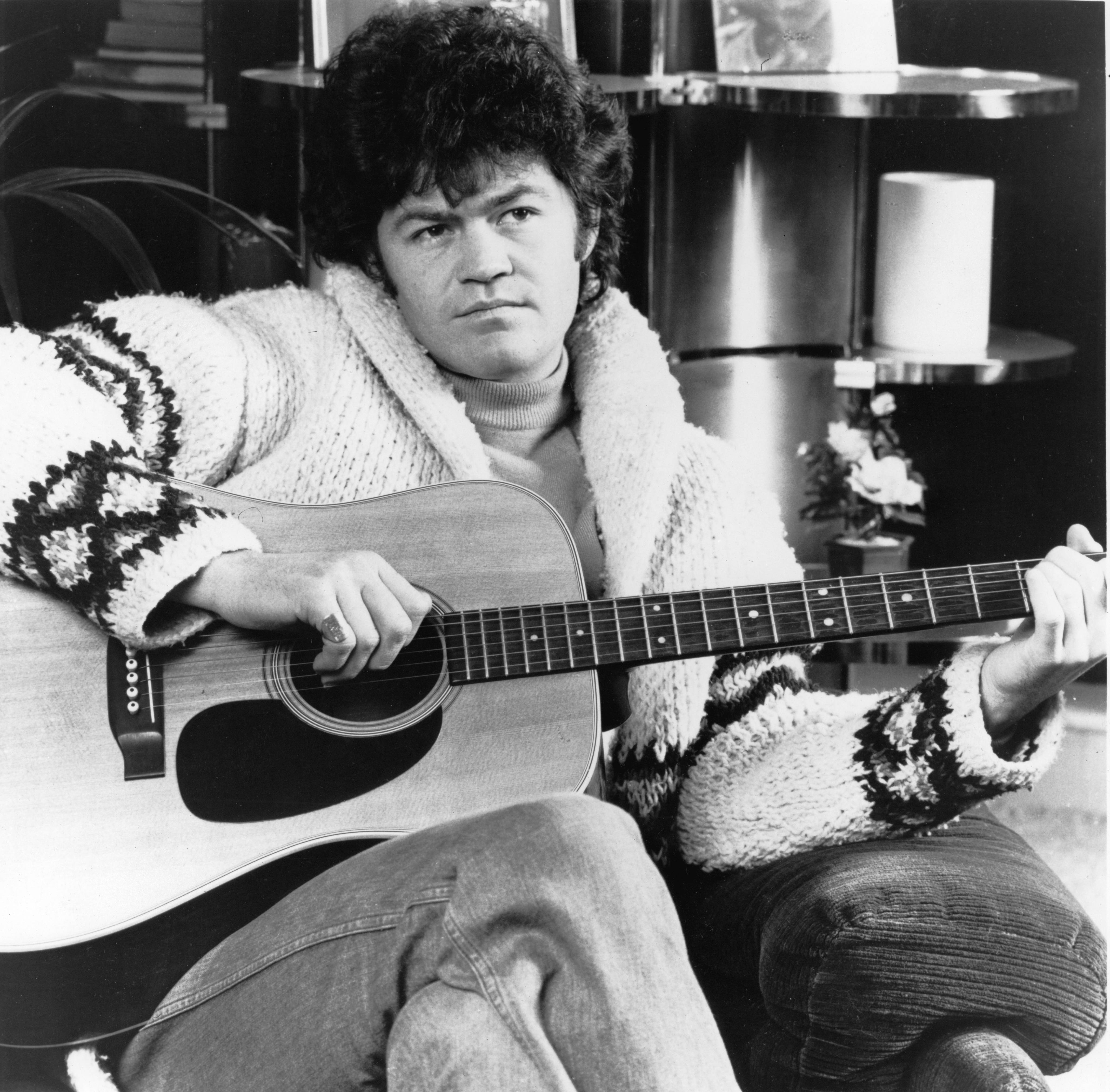 The Monkees' Micky Dolenz holding a guitar