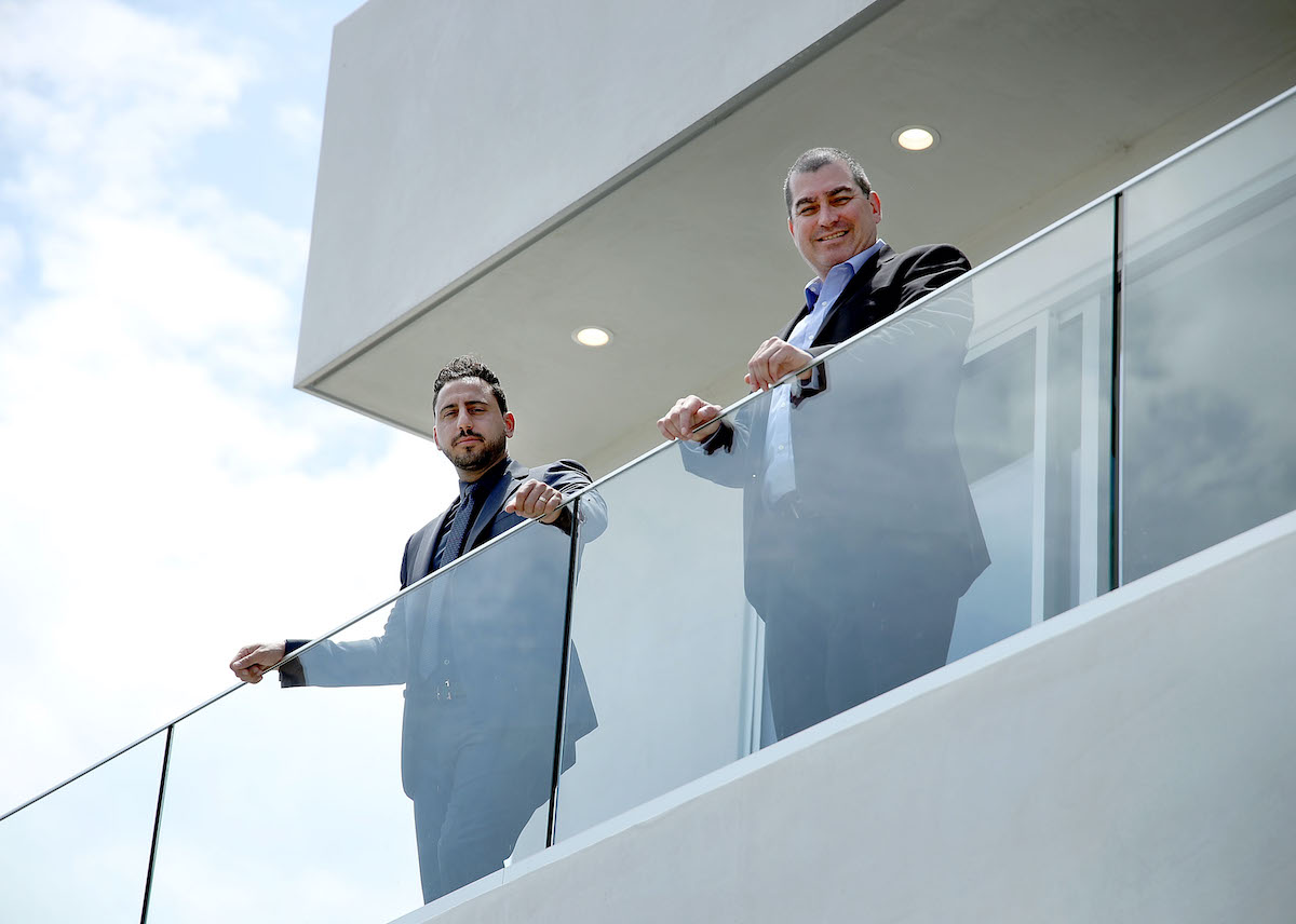 'Million Dollar Listing Los Angeles' star Josh Altman and Ilan Kenig smiling from a balcony