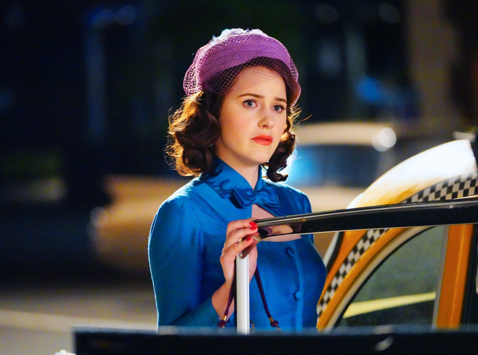 Rachel Brosnahan who plays Midge Maisel on 'The Marvelous Mrs. Maisel' stands in front of a cab