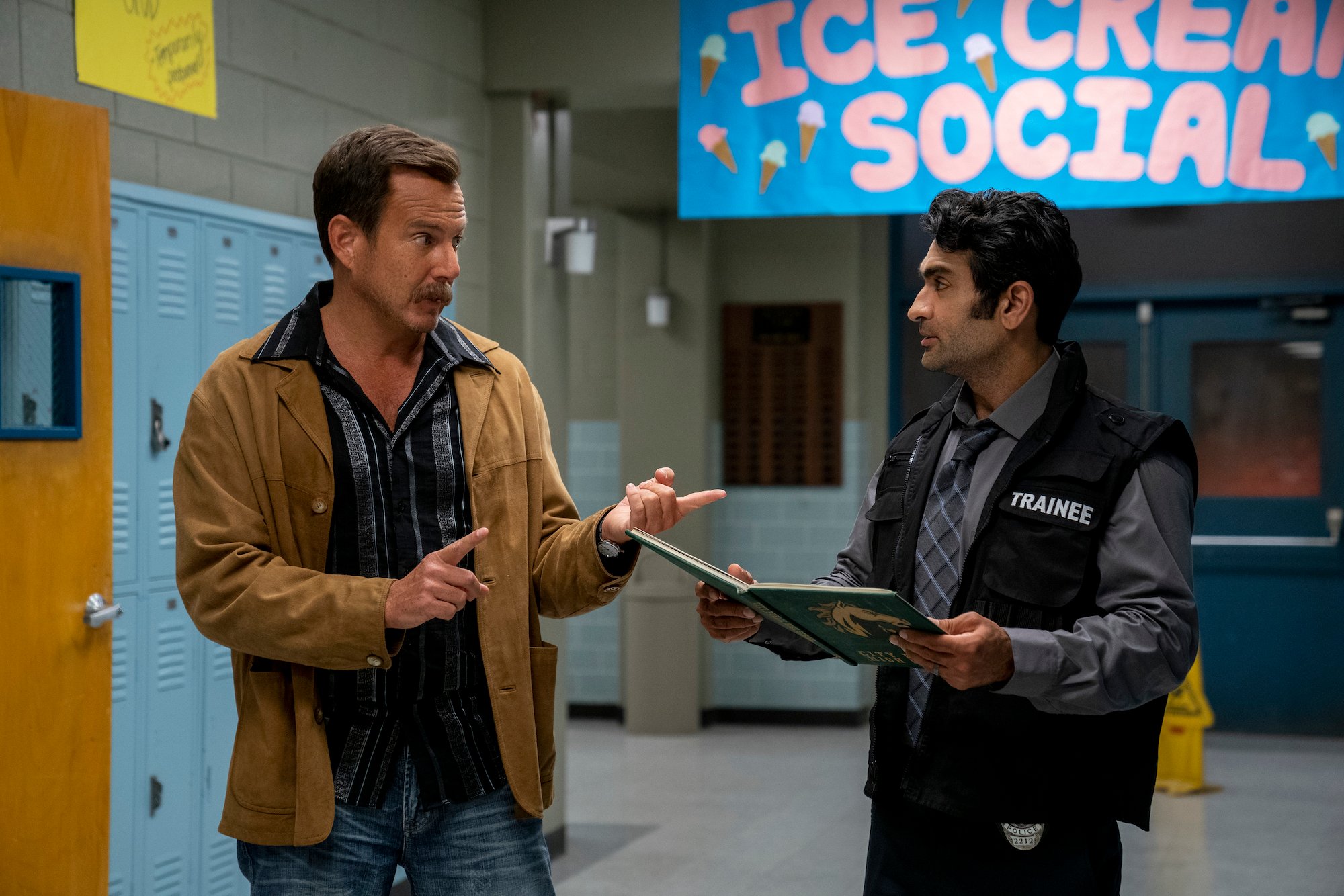 'Murderville' star Will Arnett stands next to celebrity guest Kumail Nanjiani in the halls of a high school.