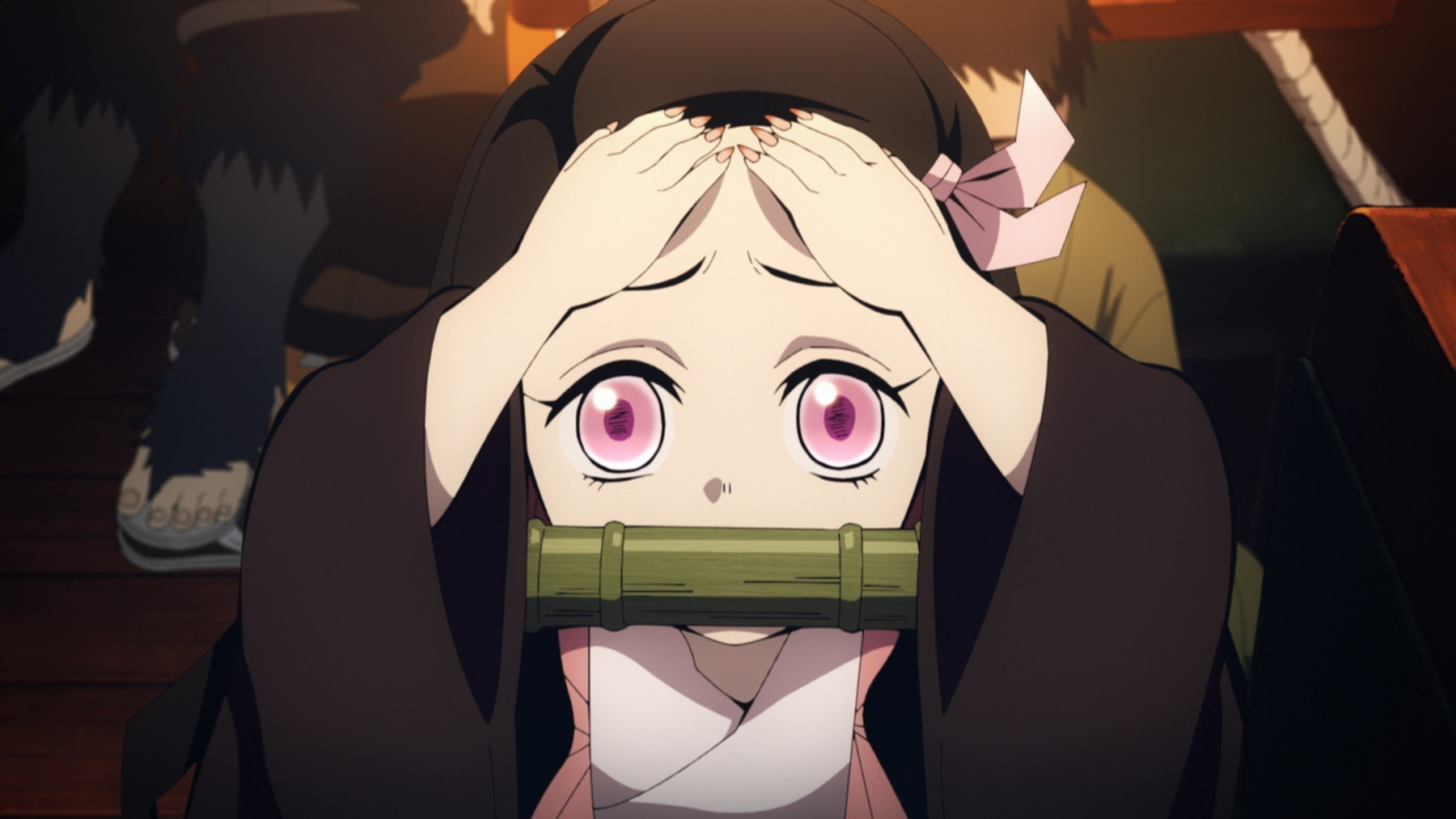 Nezuko Kamado in 'Demon Slayer's Mugen Train Arc. She looks distressed and is holding her head.
