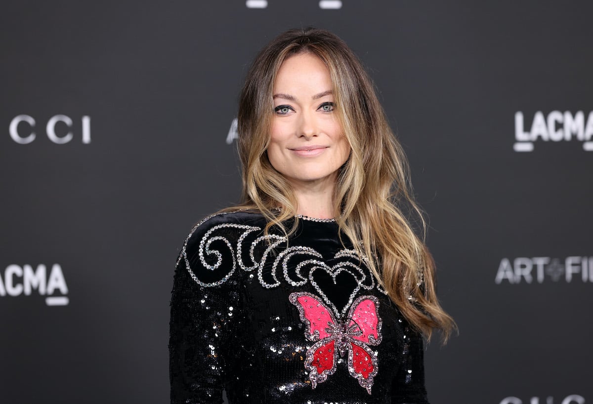 Olivia Wilde smiling in front of a black background