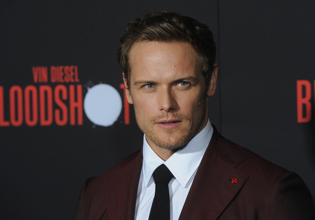 Outlander star Sam Heughan wearing a maroon suit and black tie arrives for the Premiere Of Sony Pictures' "Bloodshot" held at The Regency Village on March 10, 2020 in Los Angeles, California.