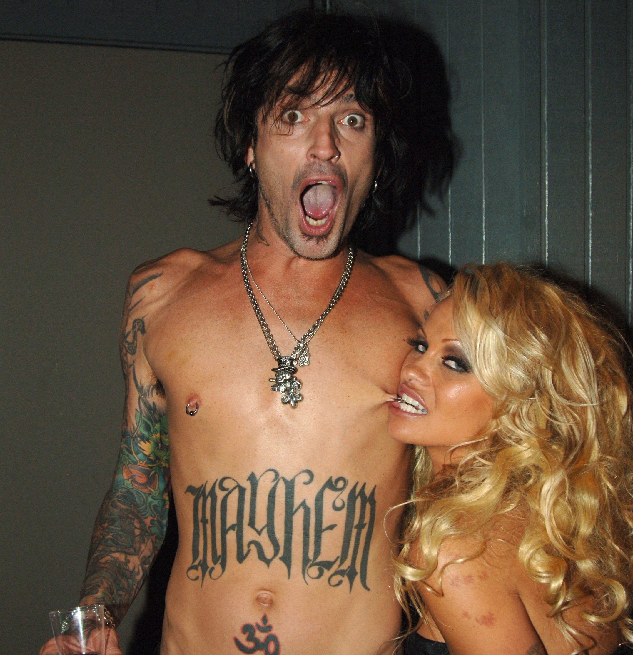 Pamela Anderson biting Tommy Lee's piercing
