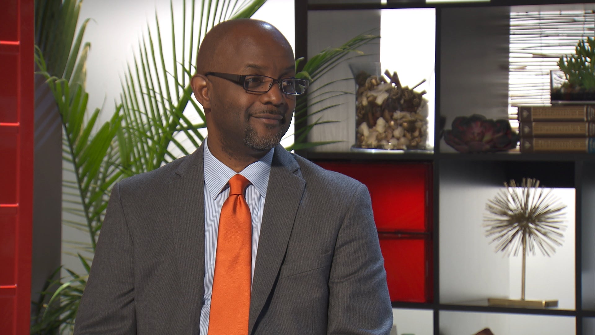 Pastor Cal, wearing a gray suit and orange tie, in an episode of 'Married at First Sight'