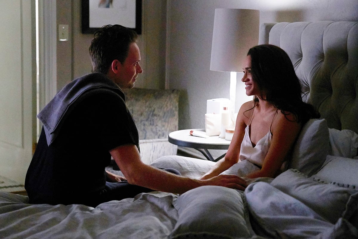 Patrick J. Adams as Michael Ross and Meghan Markle as Rachel Zane smiling on the set of 'Suits