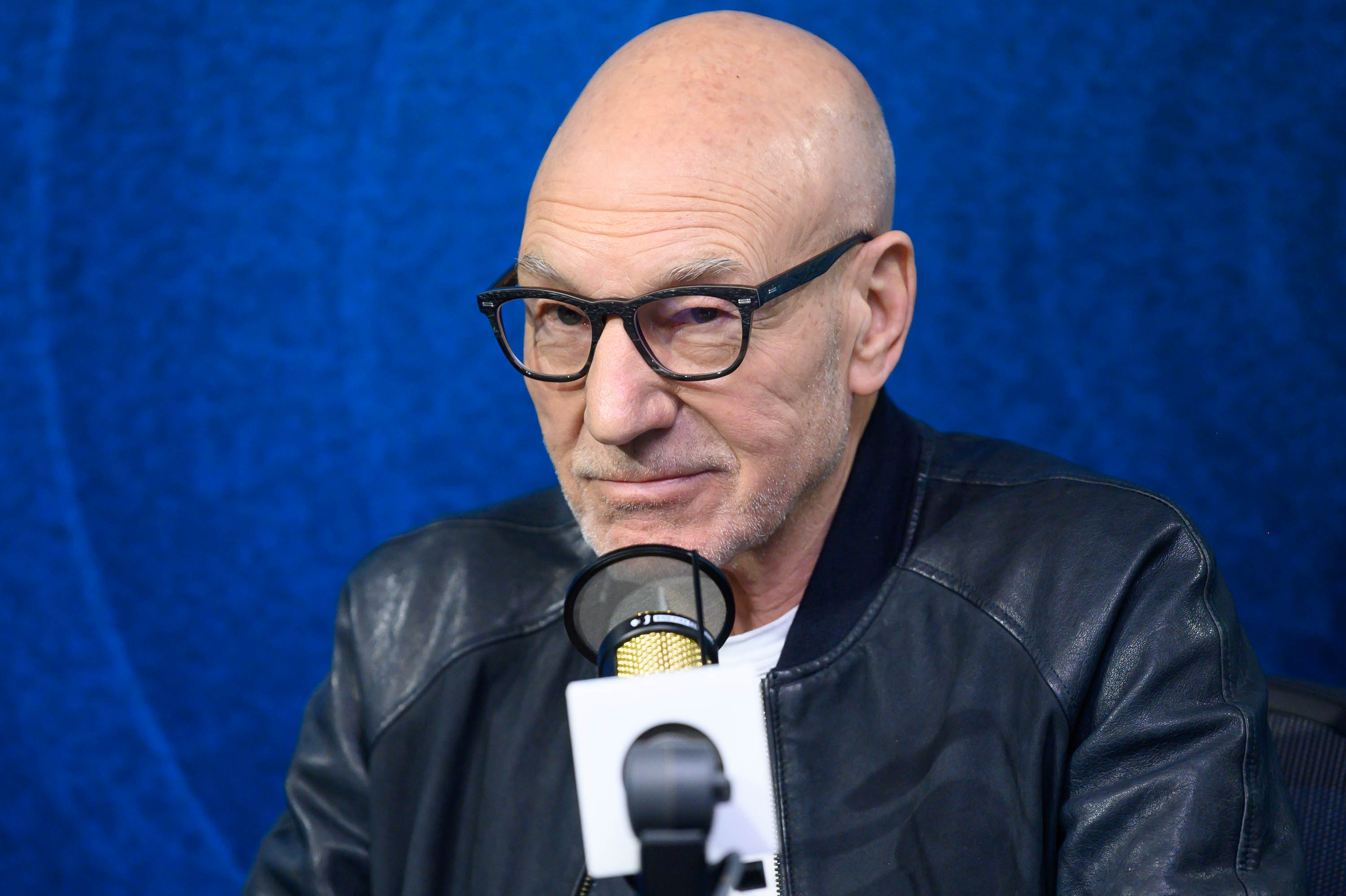 Patrick Stewart, who many fans believe is in 'Doctor Strange in the Multiverse of Madness,' wears a black leather jacket over a white shirt and black-framed glasses.