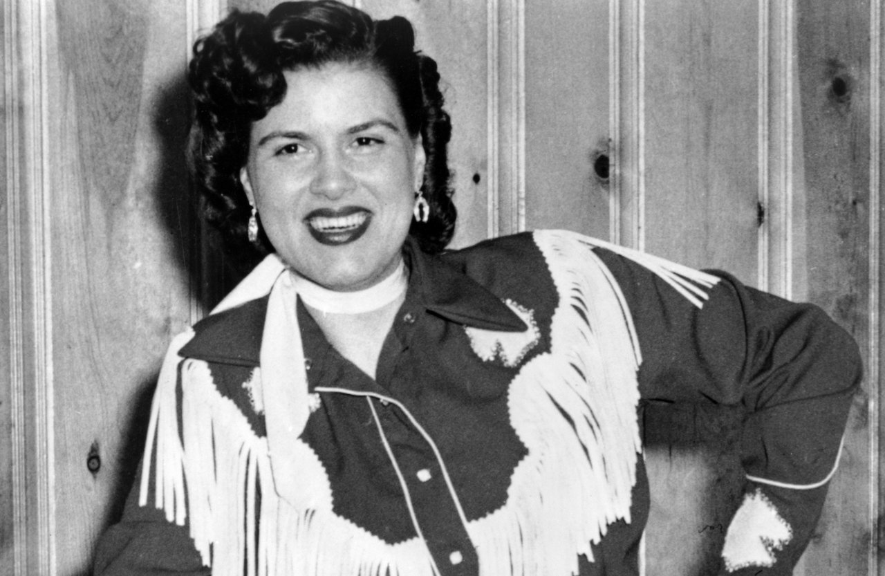 Patsy Cline poses and smiles in a fringe dress c. 1958