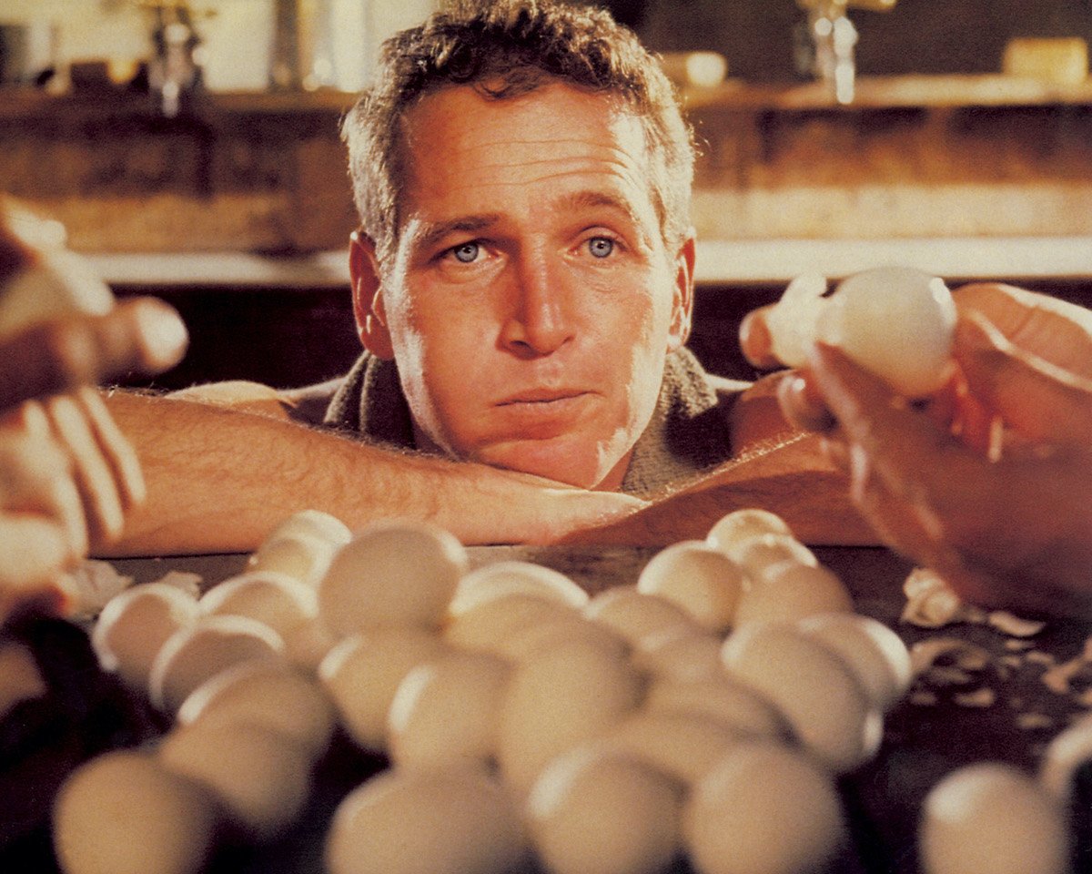 Paul Newman looks at a pair of hands holding eggs in ‘Cool Hand Luke’