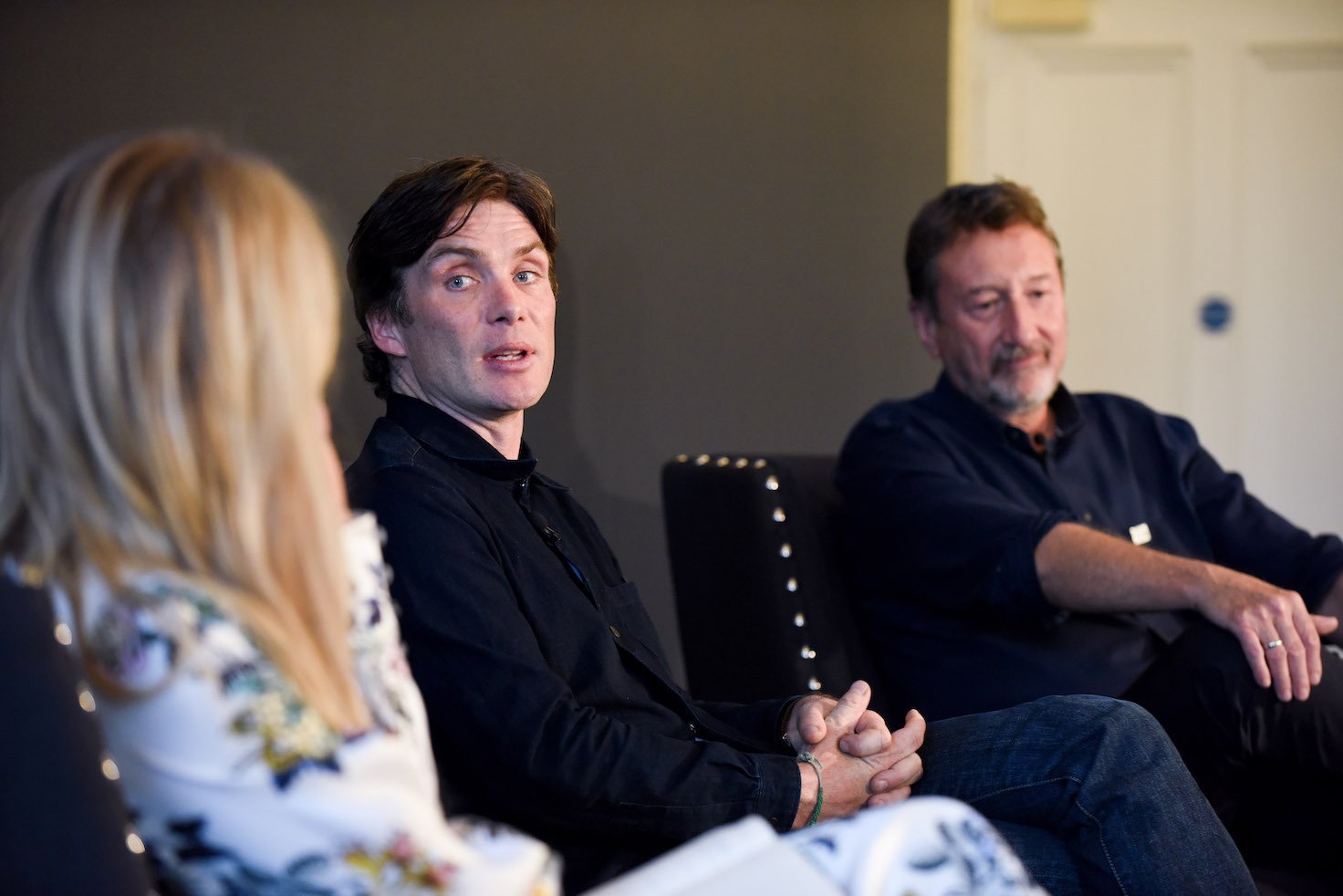 Edith Bowman, Cillian Murphy, and Steven Knight from 'Peaky Blinders' Season 6 talking in a room while sitting adjacent to each other