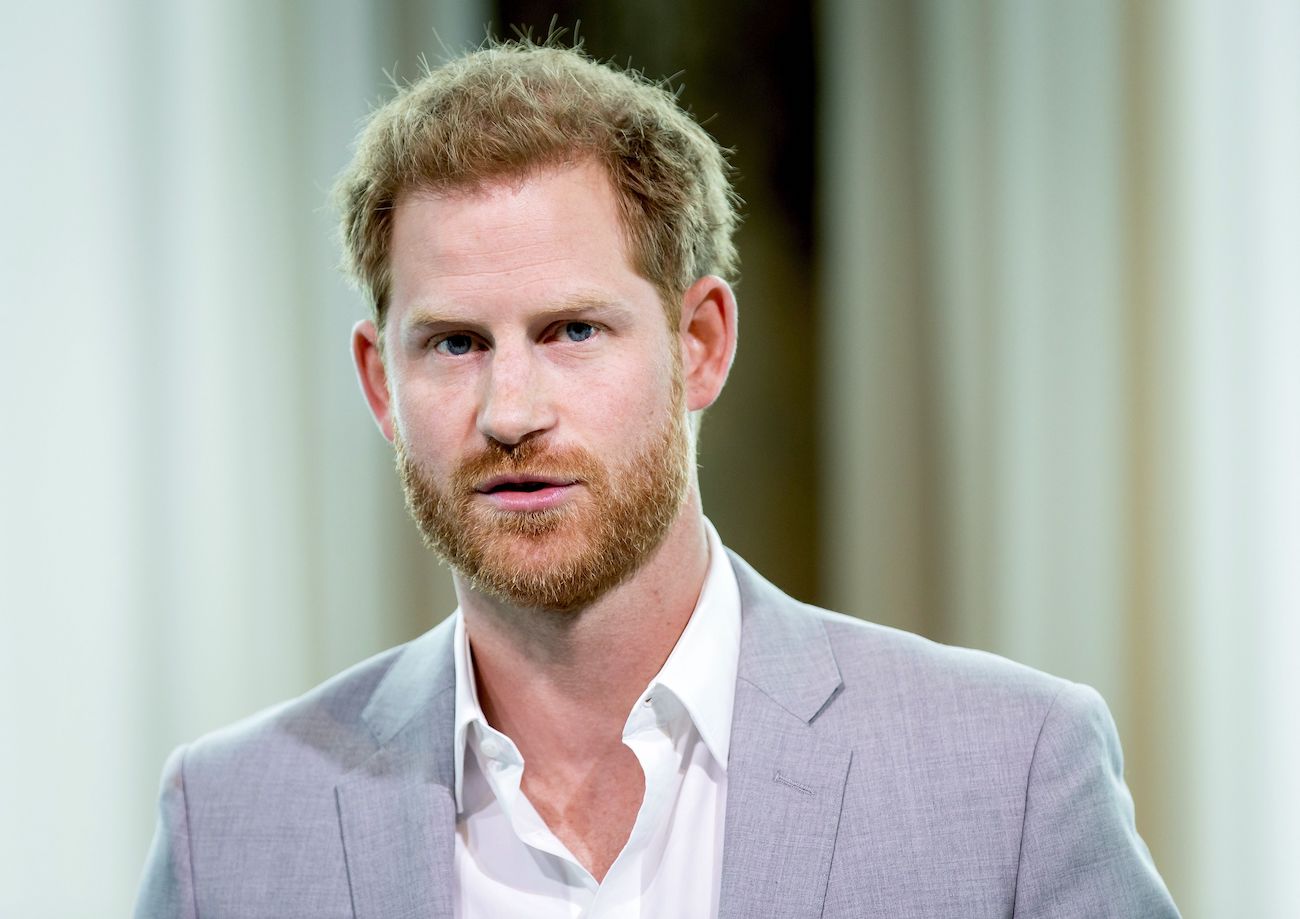 Prince Harry looking on in a gray suit