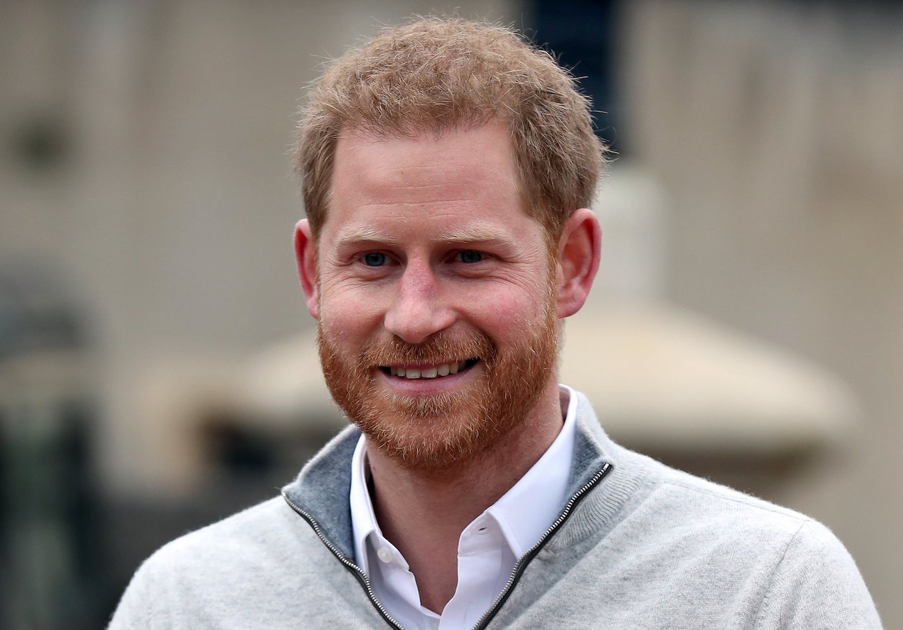 Prince Harry smiling in the direction of the camera, close up