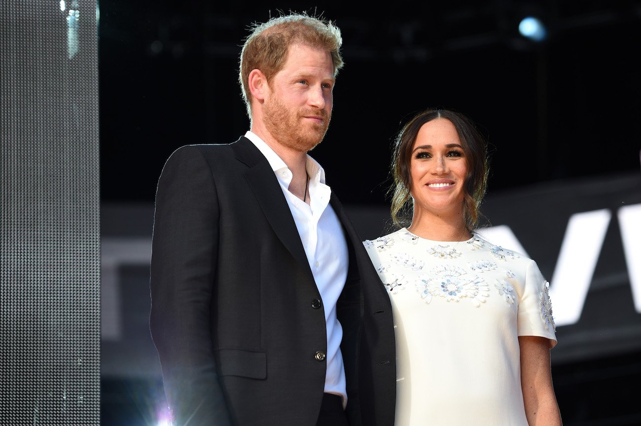 Prince Harry wearing a suit and Meghan Markle wearing a white dress