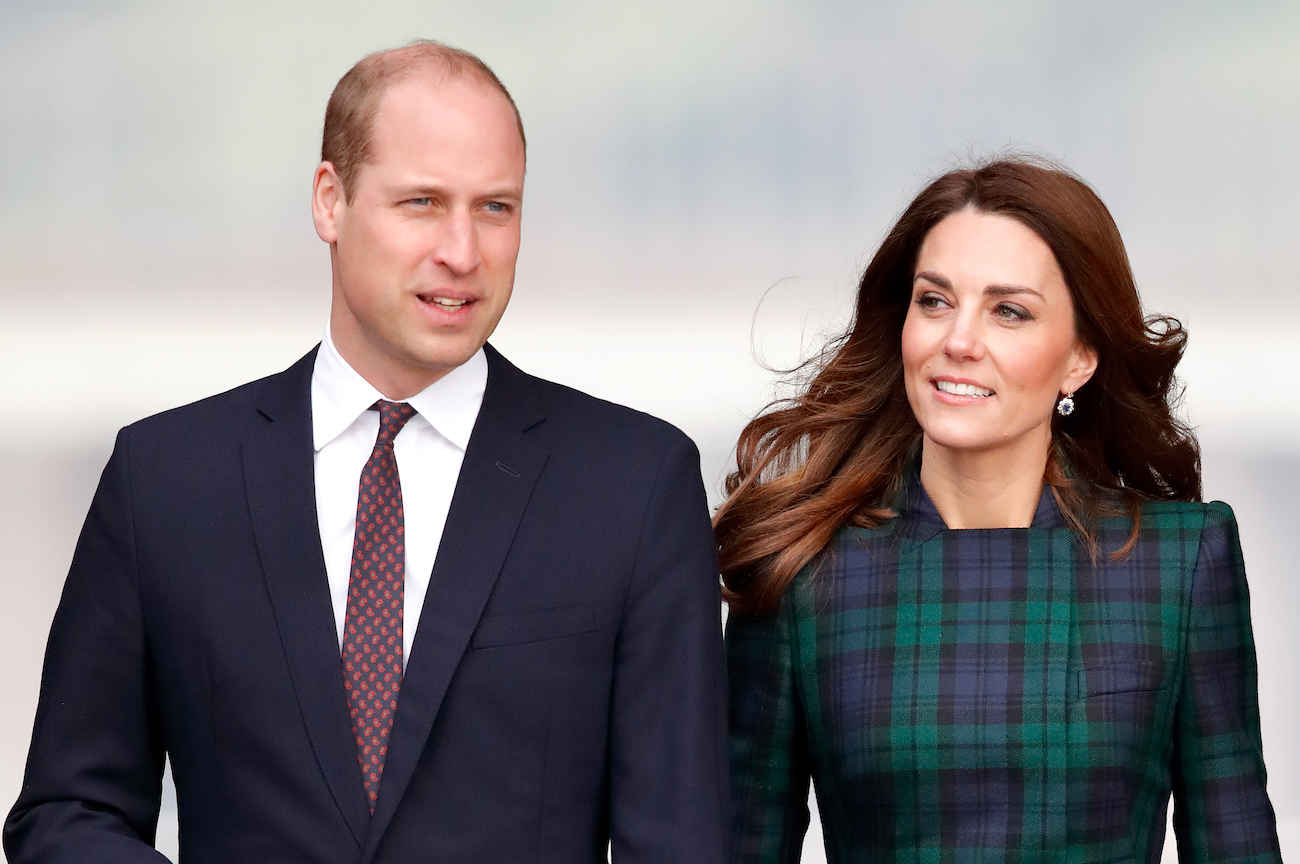Prince William and Kate Middleton standing next to each other and looking on