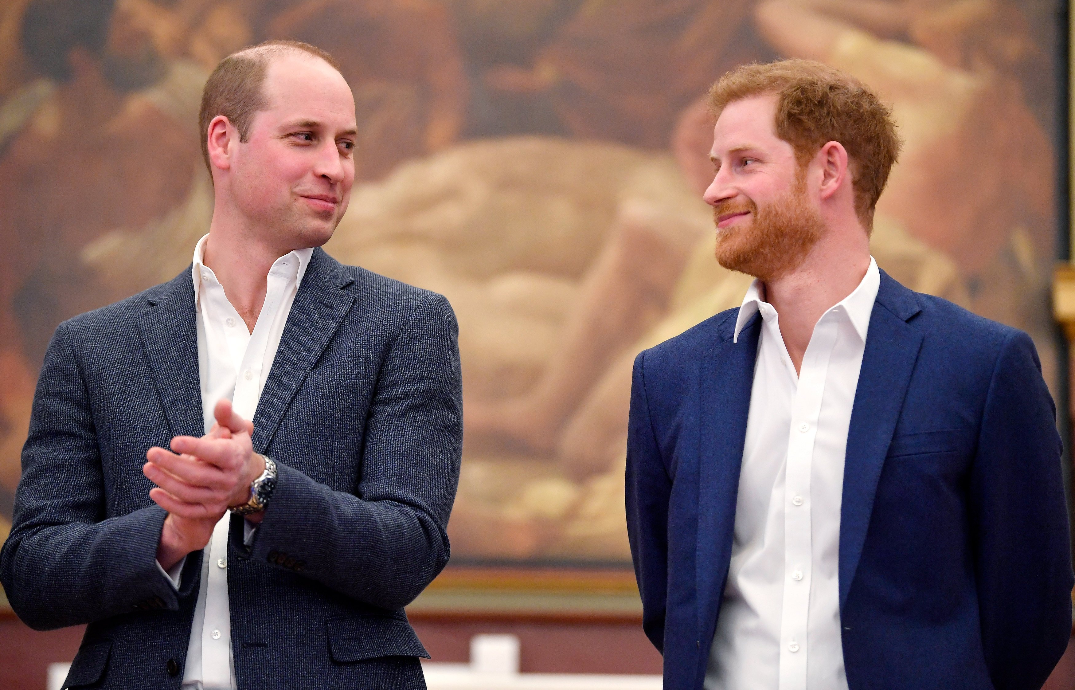 Prince William and Prince Harry smiling at one another at the opening of the Greenhouse Sports Centre