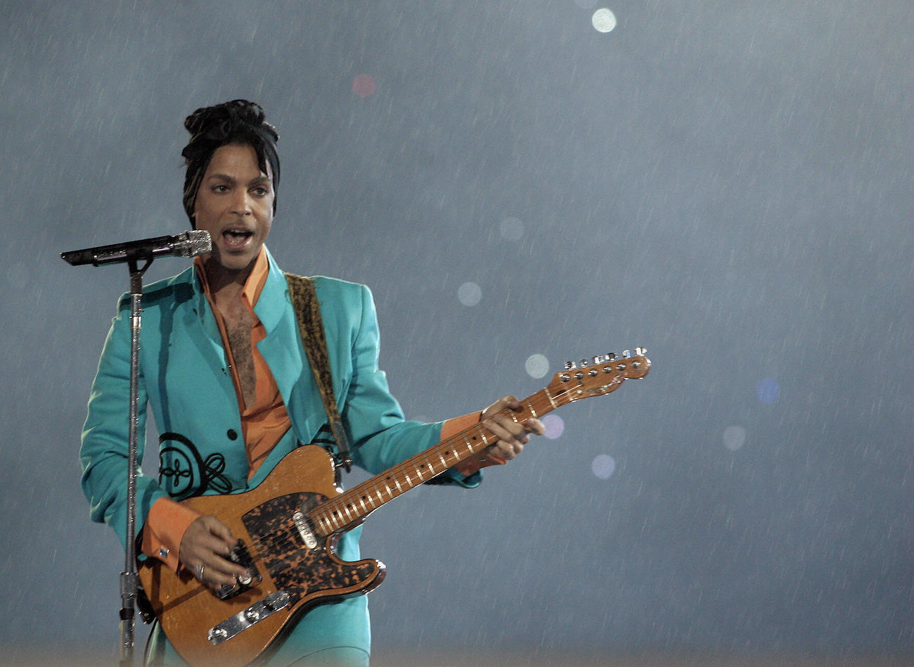 Prince plays guitar in a blue outfit at the 2007 Super Bowl halftime show